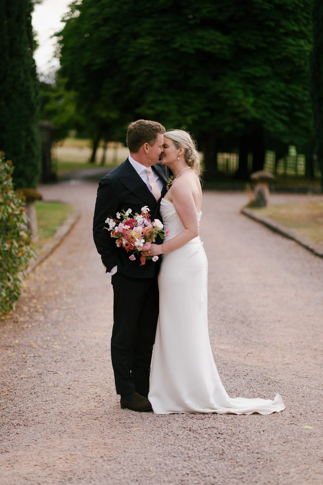 Editorial wedding portrait of bride and groom kissing at Dewsall Court