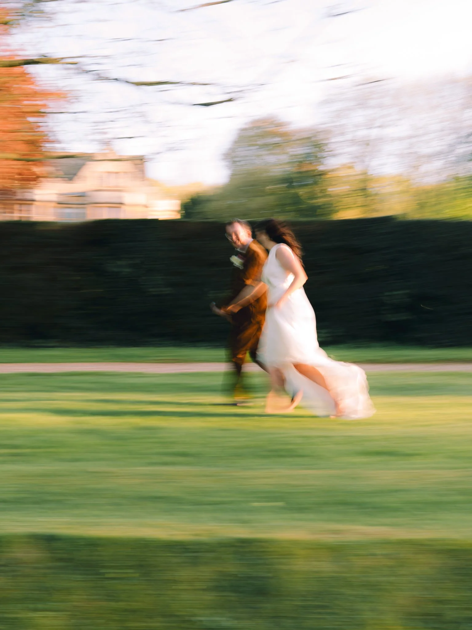 Editorial slow shutter shot of bride and groom running at Coombe Lodge