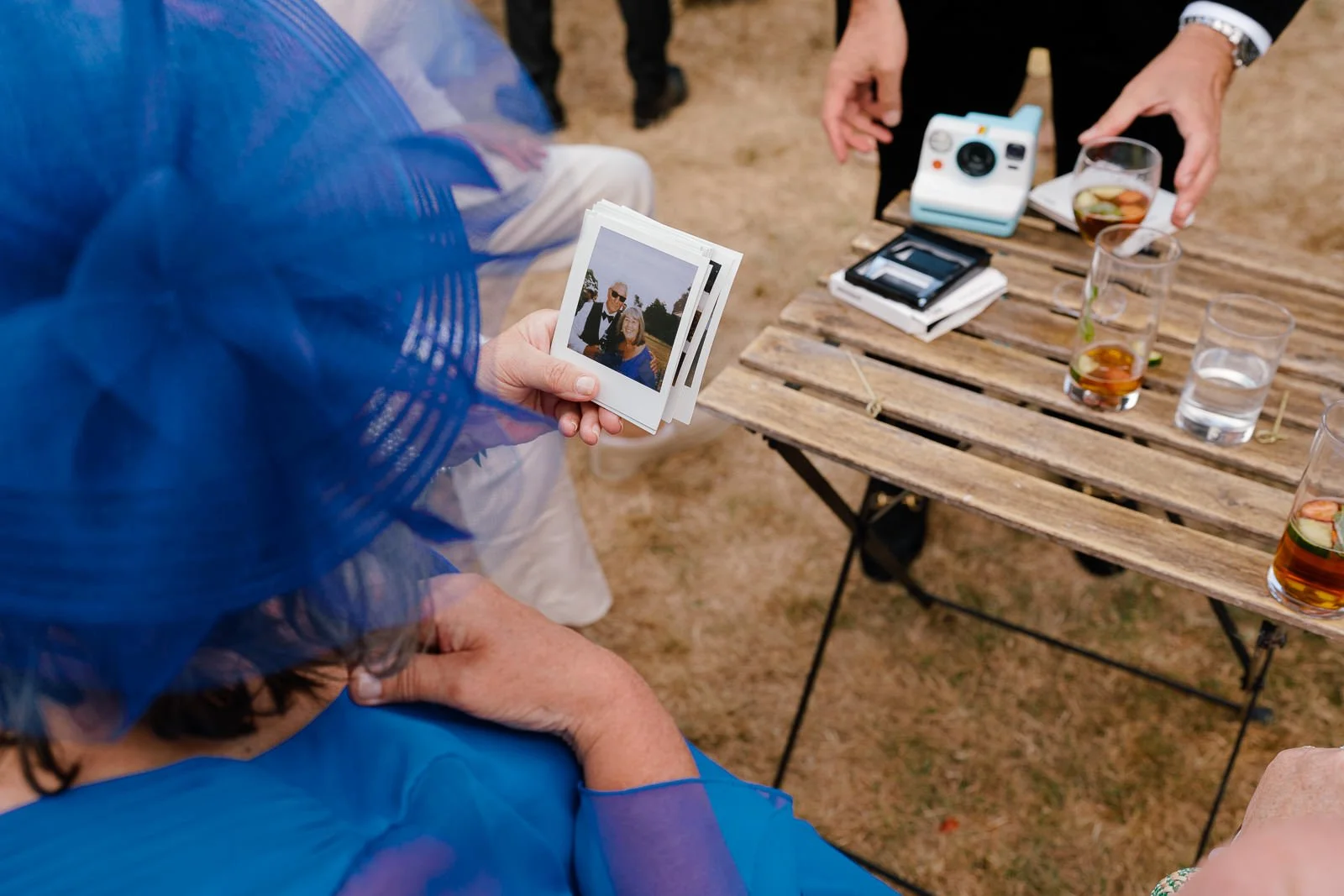 Mother of the groom looking at Polaroid wedding photos