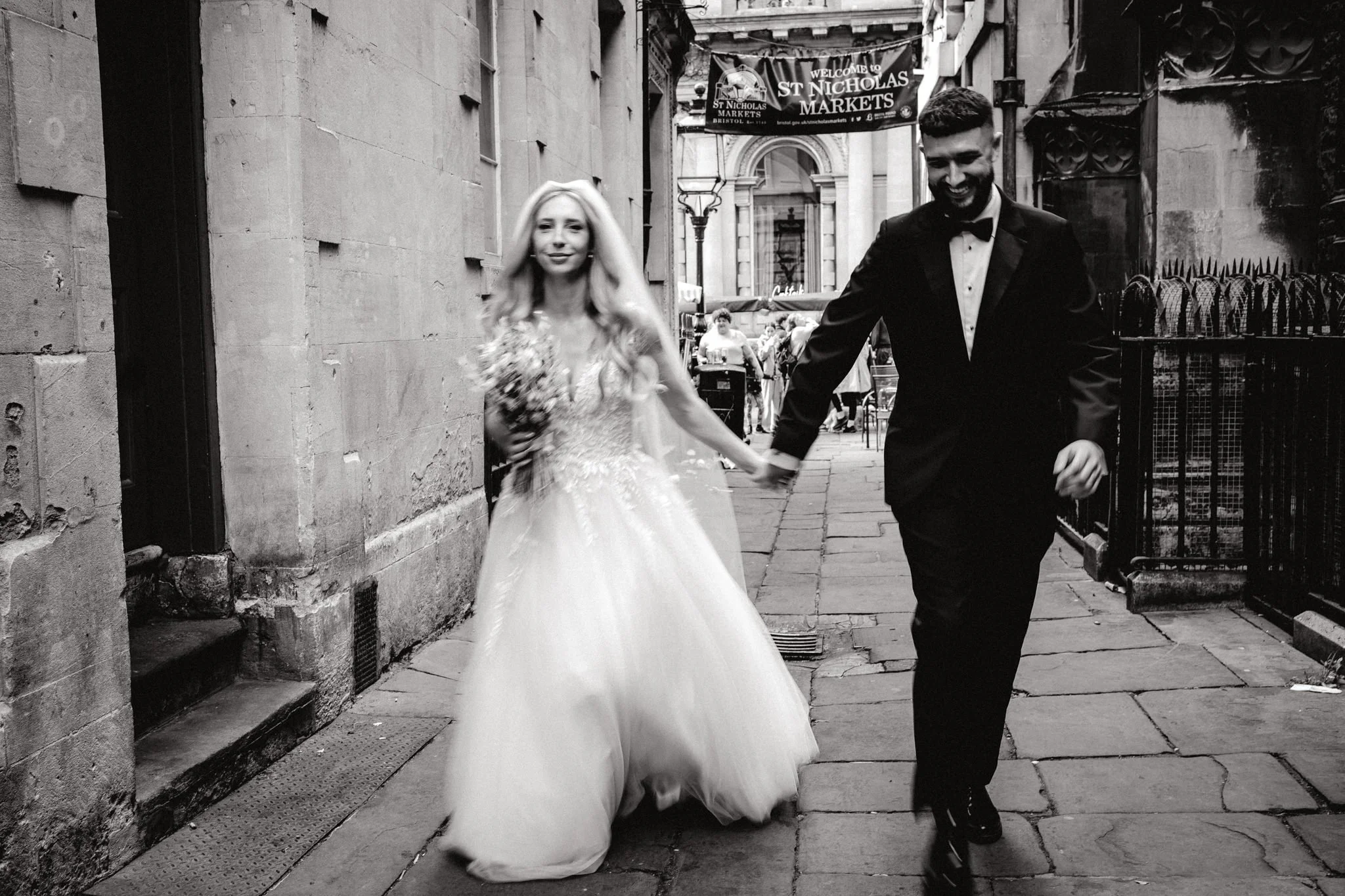 A wedding in central bristol with the bride and groom walking through St Nicholas Market