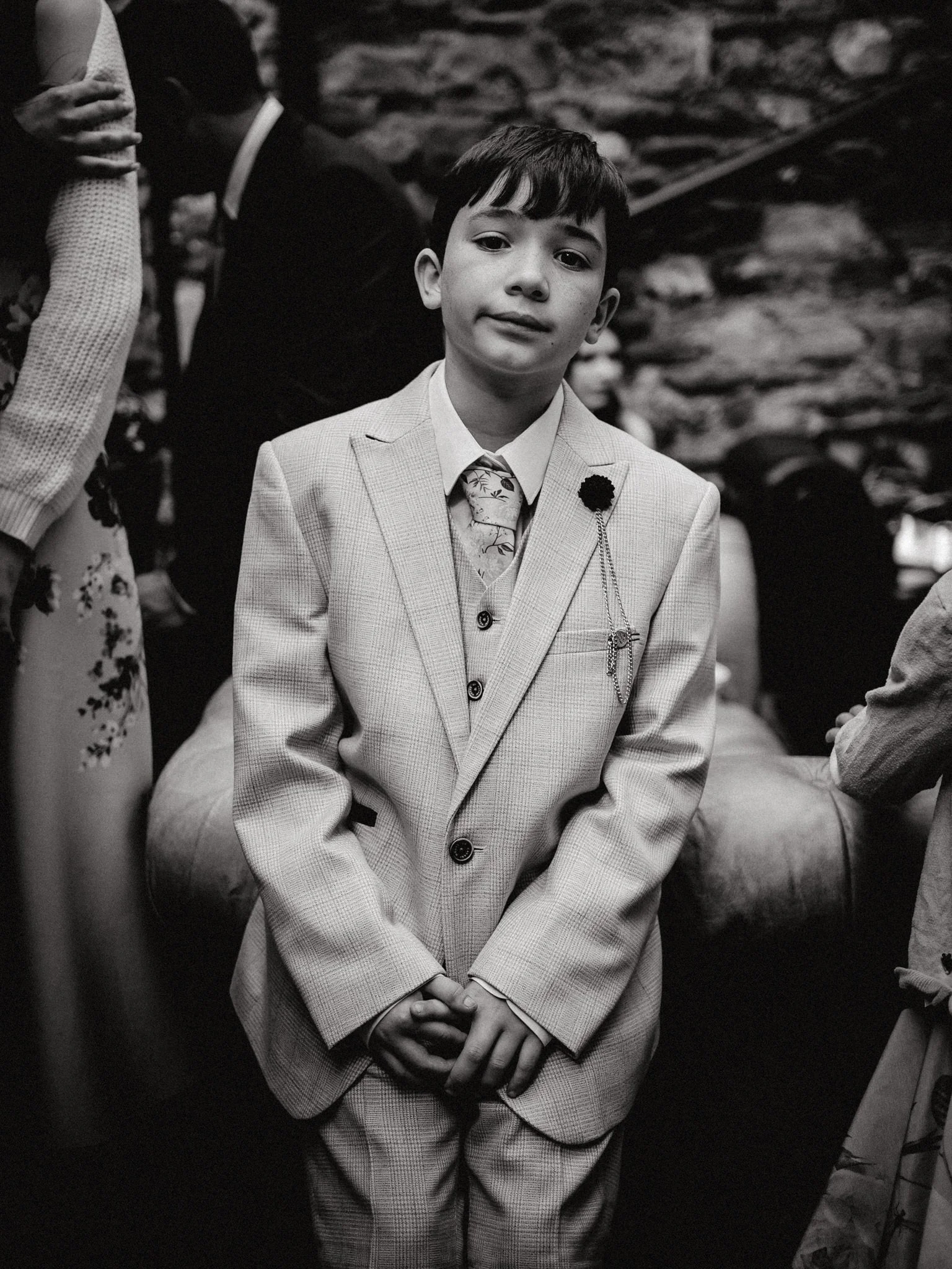 wedding photography of a young boy in a big suit pulling a serious face