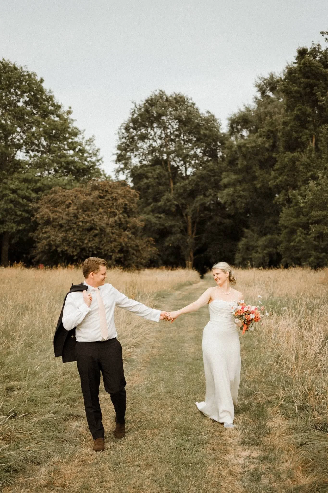 Bride and groom at Dewsall Court in the gardens laughing together and having fun