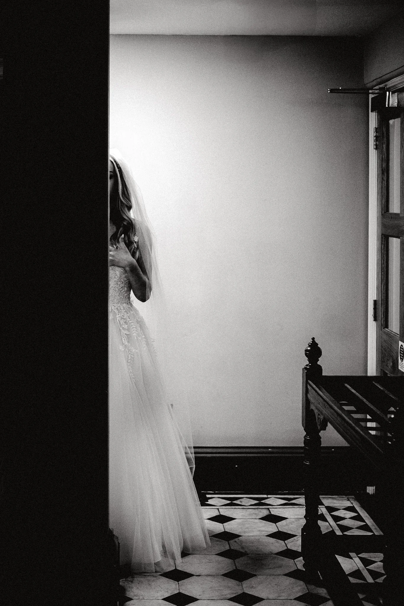 A bride taking a moment alone behind a pillar before her wedding at Bristol Register Office