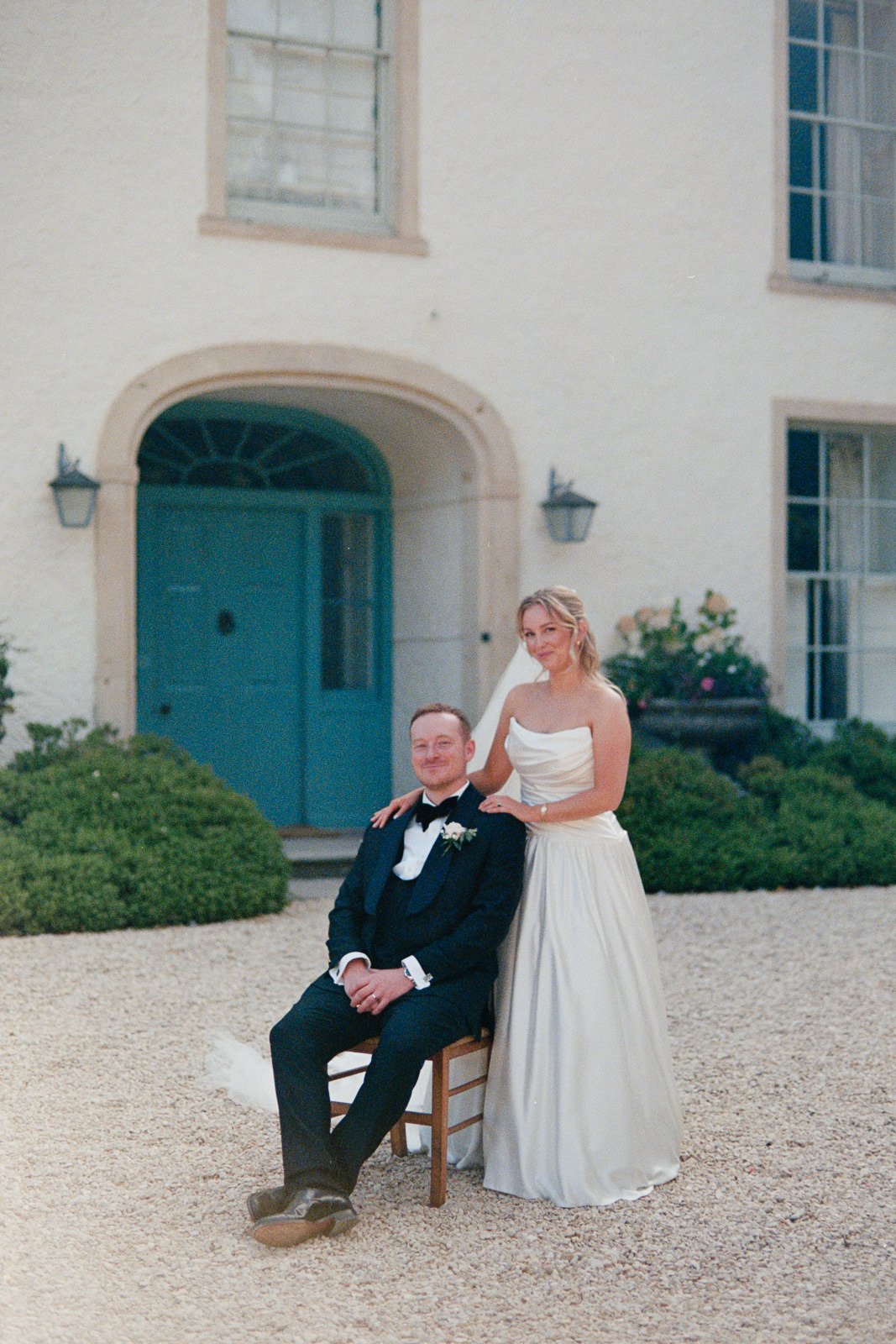 Groom seated with bride at golden hour, film photo with light leak, Matara