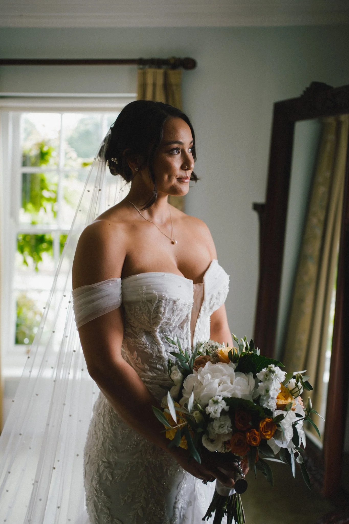 Beautiful part asian bride waiting for the ceremony with flowers at Birtsmorton Court