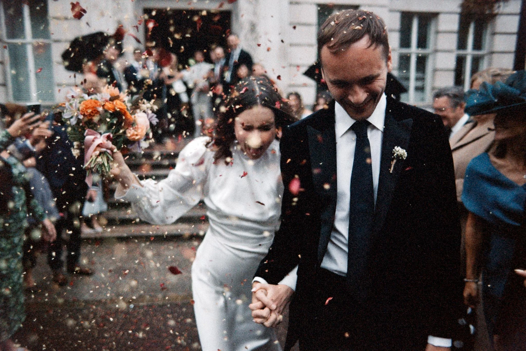 Bride and groom with autumnal confetti at a town hall wedding on analogue film