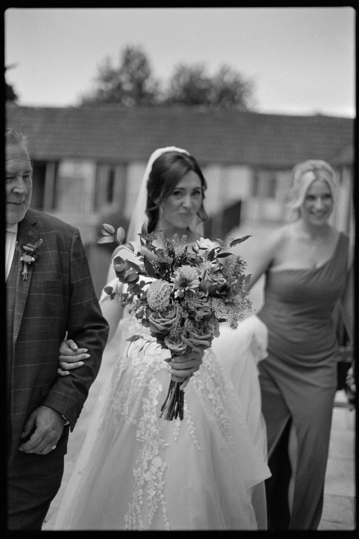 wedding photography of bride pushing flowers toward the camera in black and white