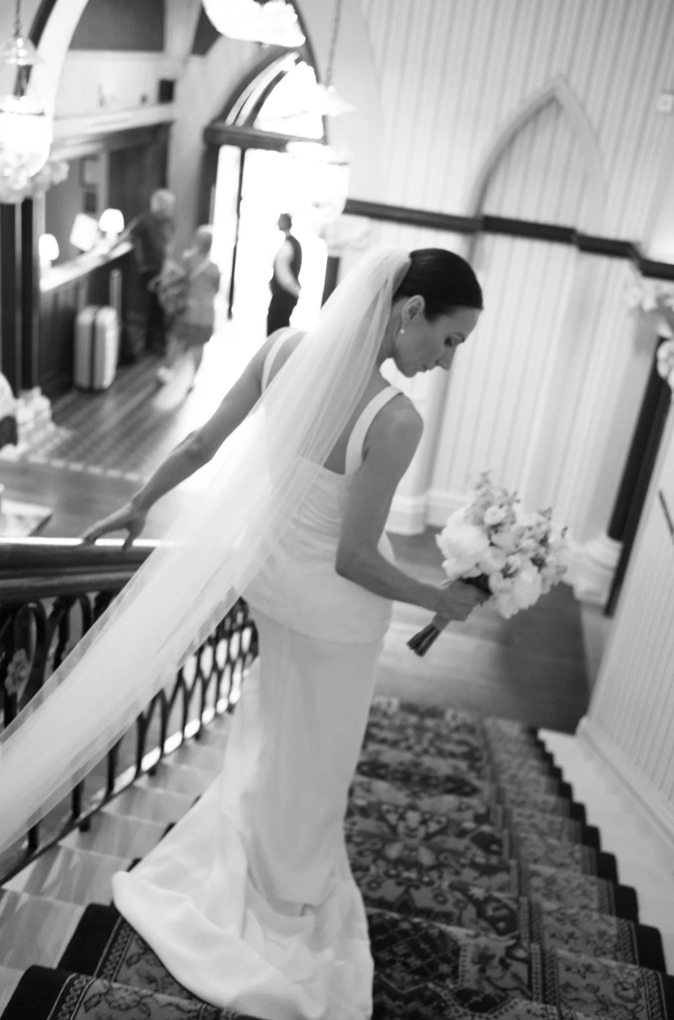 wedding photography of a bride walking down the stairs at the Randolph Hotel in Oxford