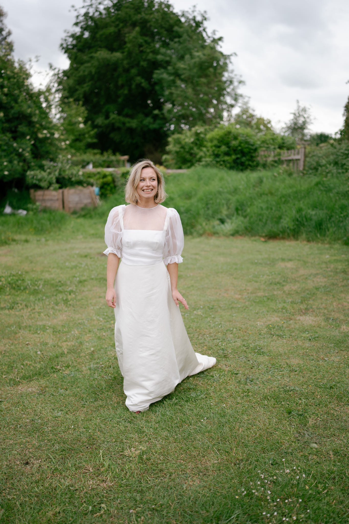 Beautiful blonde bride standing on the grass at her wedding