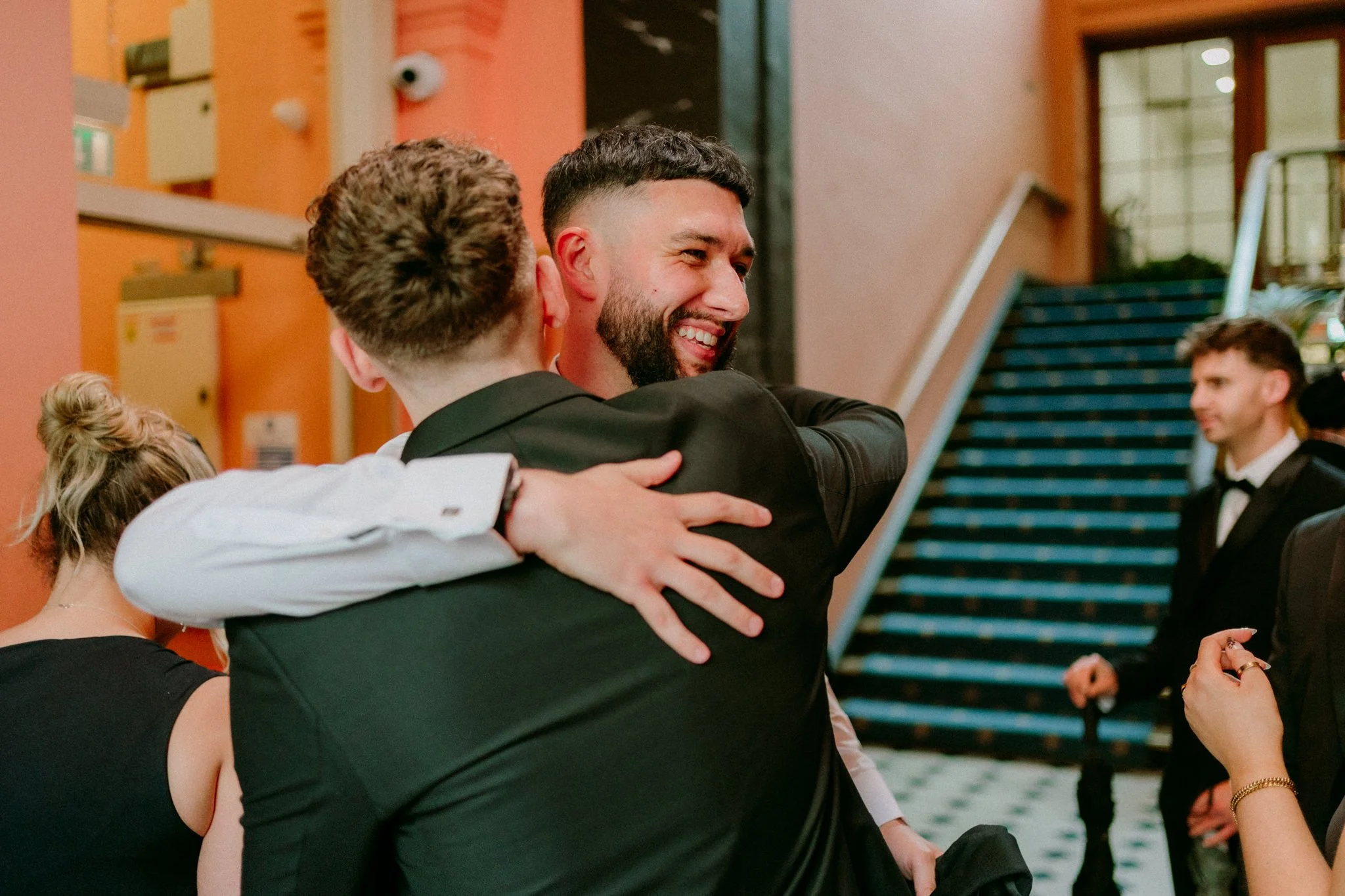 A groom hugs his friend at Bristol Registry Office