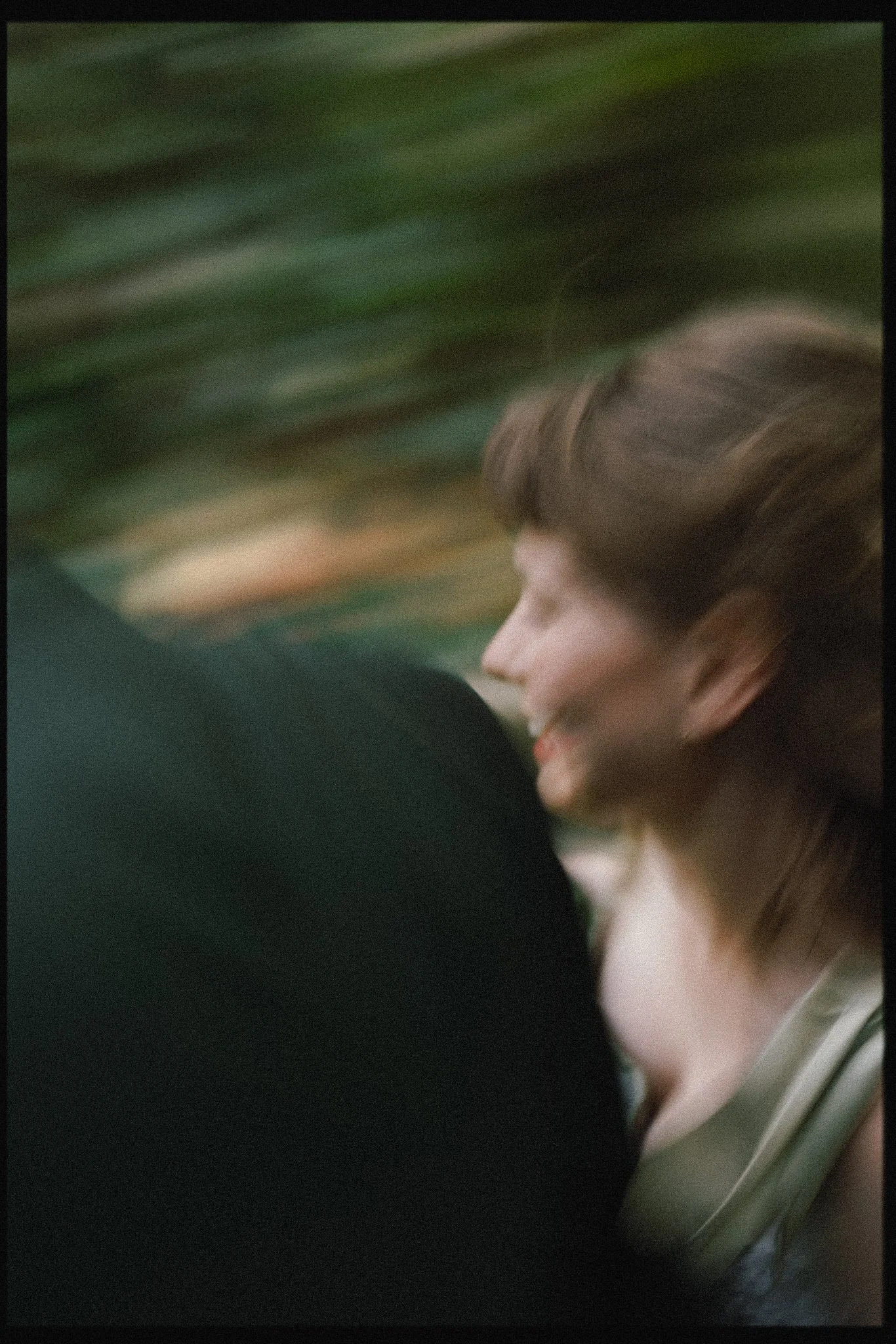 Slow shutter of bride running past the camera in colour with lots of film grain at Arnos Vale in Bristol