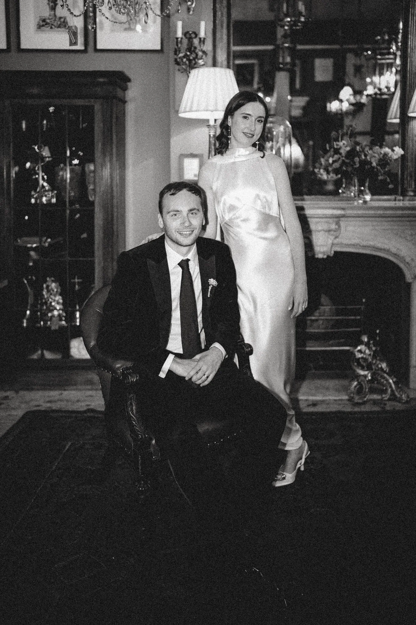 A couple pose inside Brunswick House in London, they are lit by front flash and shot on black and white film