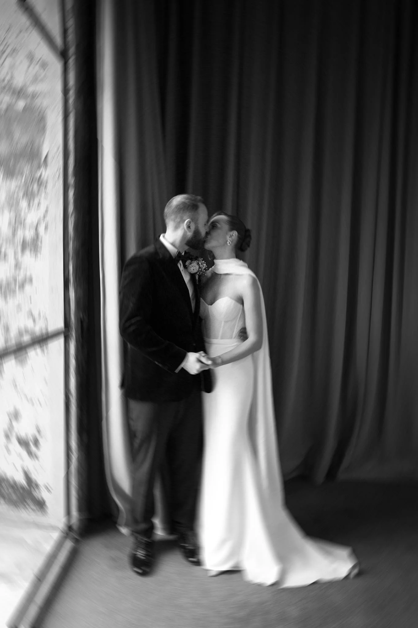 Newlyweds kissing by a window at The Mount Without in Bristol