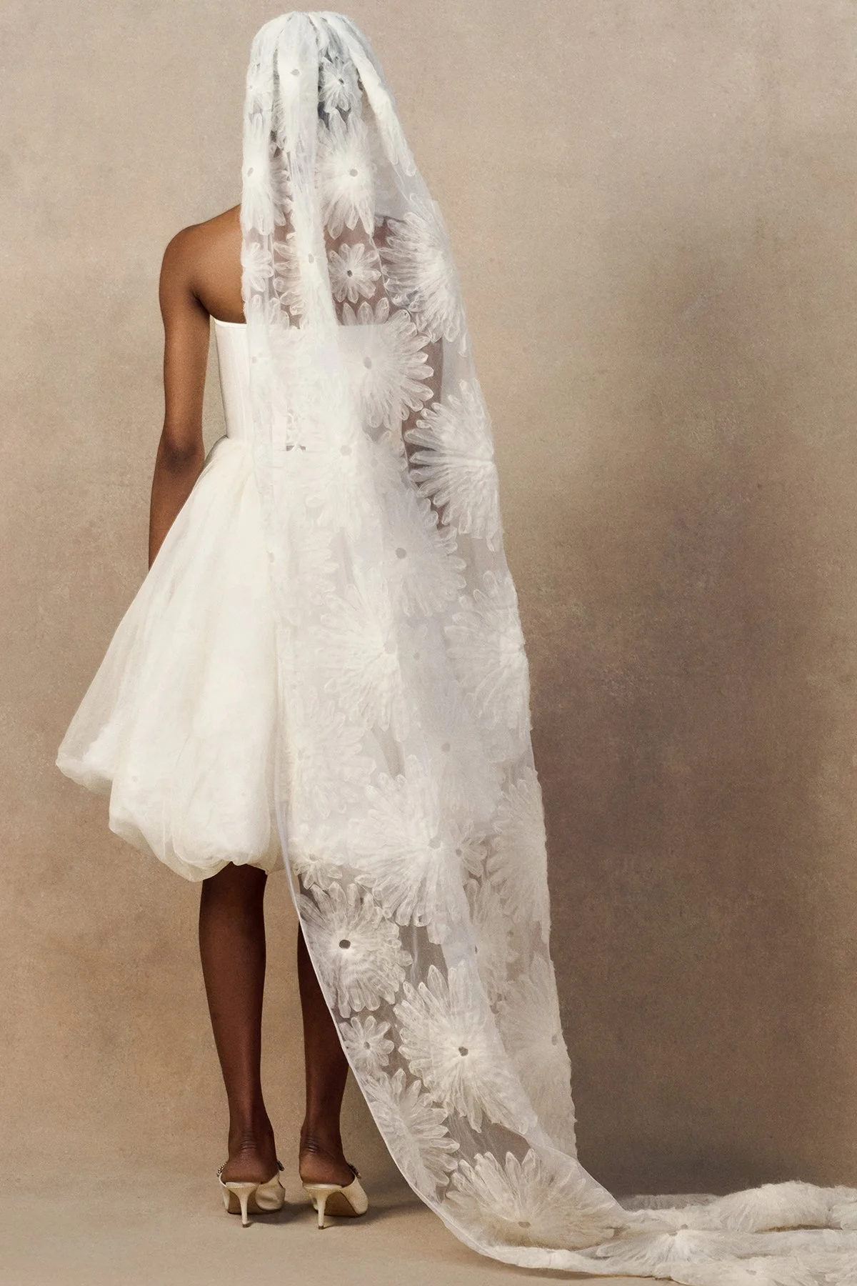 back image of bridal veil in raw-edged silk organza, featuring intricate looped daisy motifs for a textured, 3D floral effect. with phoenix corset and meg mini skirt