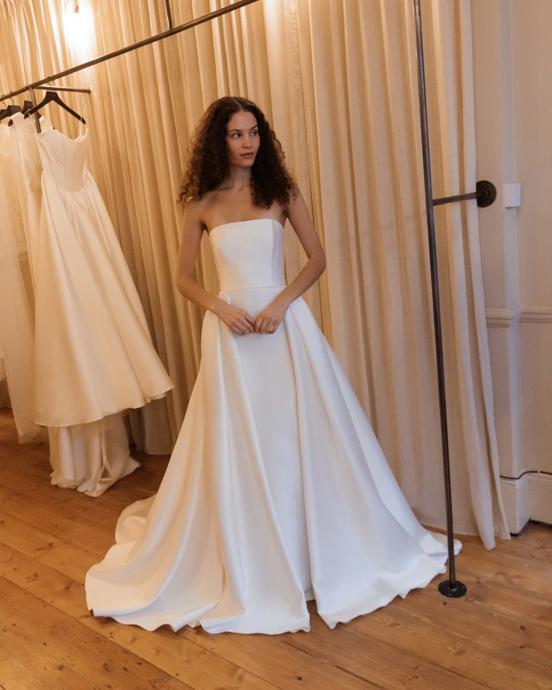 Off-the-shoulder silhouettes are all about balance. From sleeve length to veil weight and overskirt volume, proportion plays a quiet but powerful role in how the overall look feels. The right styling enhances the neckline, frames the body, and lets t