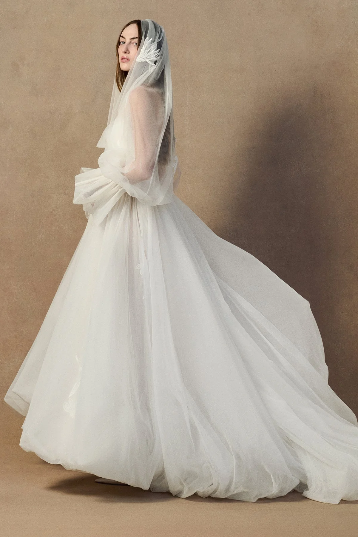 side images of the Kerry Veil in double-layered tulle with a voluminous sheer silhouette that drapes over the head and shoulders to gather at the wrist creating sleeves .jpg
