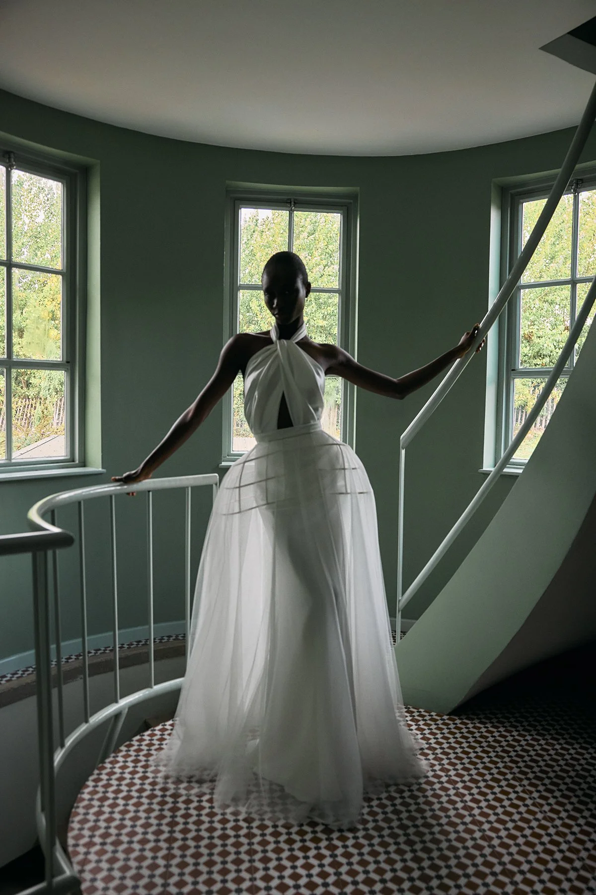 Izy wedding dress with halterneck, bias-cut slinky fabric, twisted drape front, closed back buttons, low back ties, and fit-and-flare silhouette. With the Seren skirt