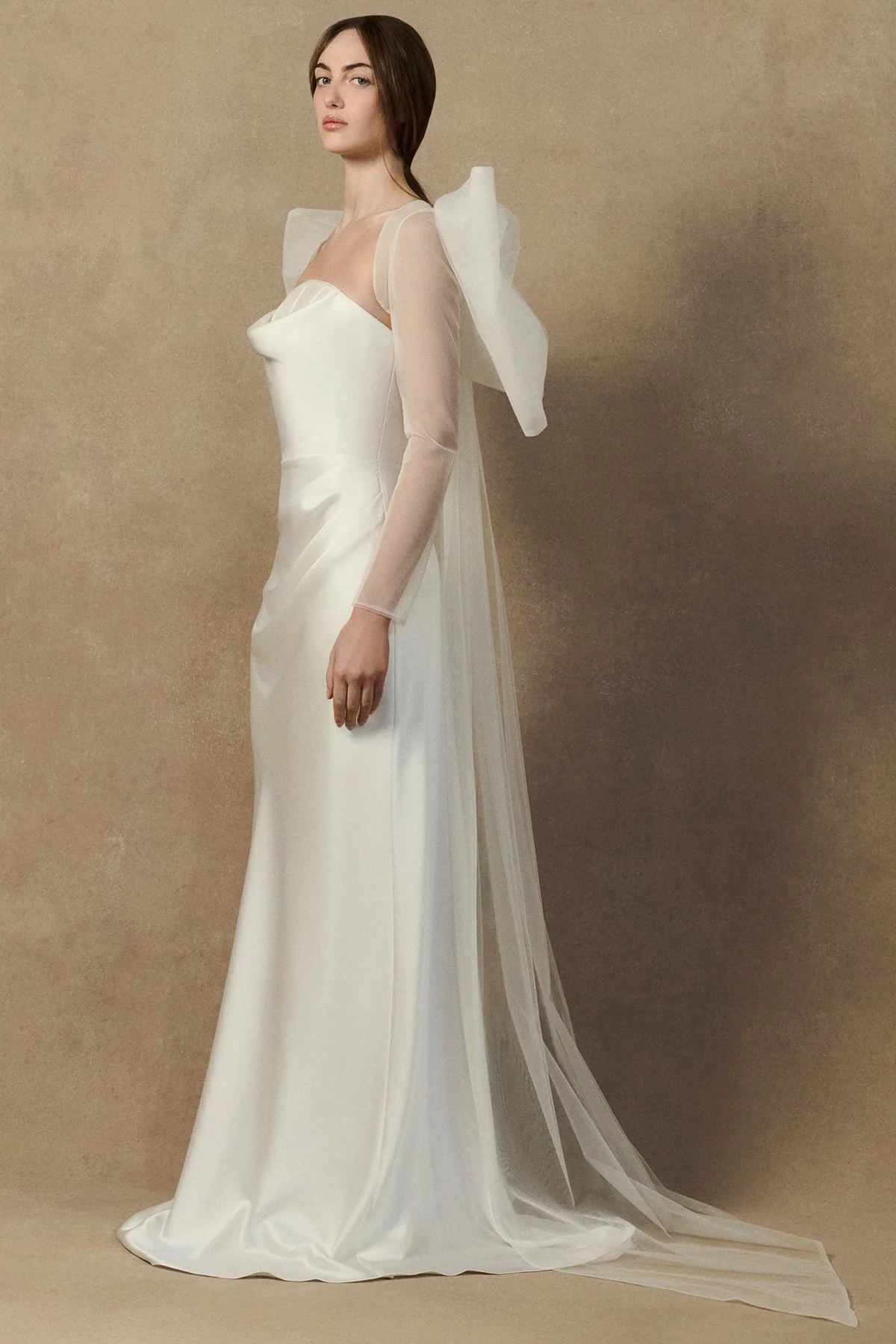 side image of oversized bridal bow jacket crafted from layered tulle, organza, and crinoline, styled as a sheer bolero. worn with herah dress