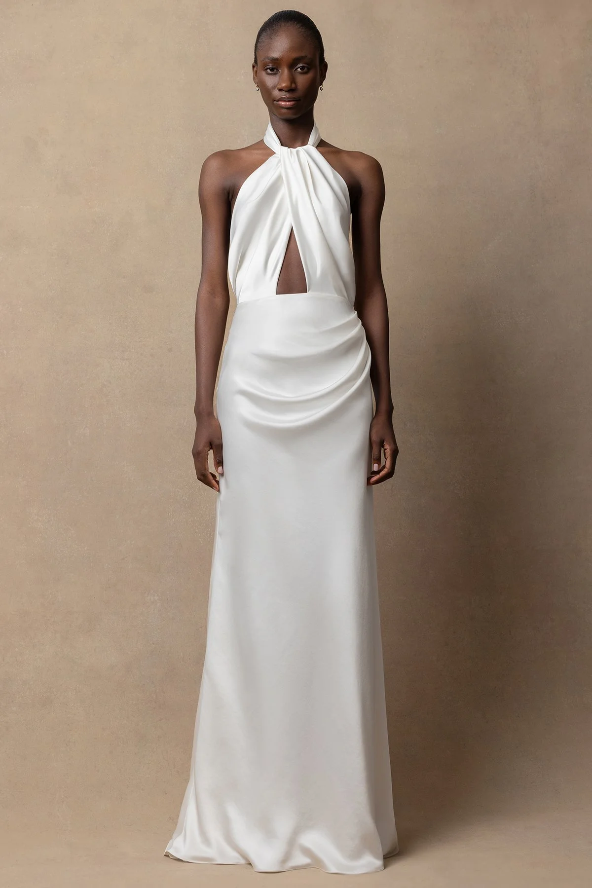 Izy wedding dress with halterneck, bias-cut slinky fabric, twisted drape front, closed back buttons, low back ties, and fit-and-flare silhouette.