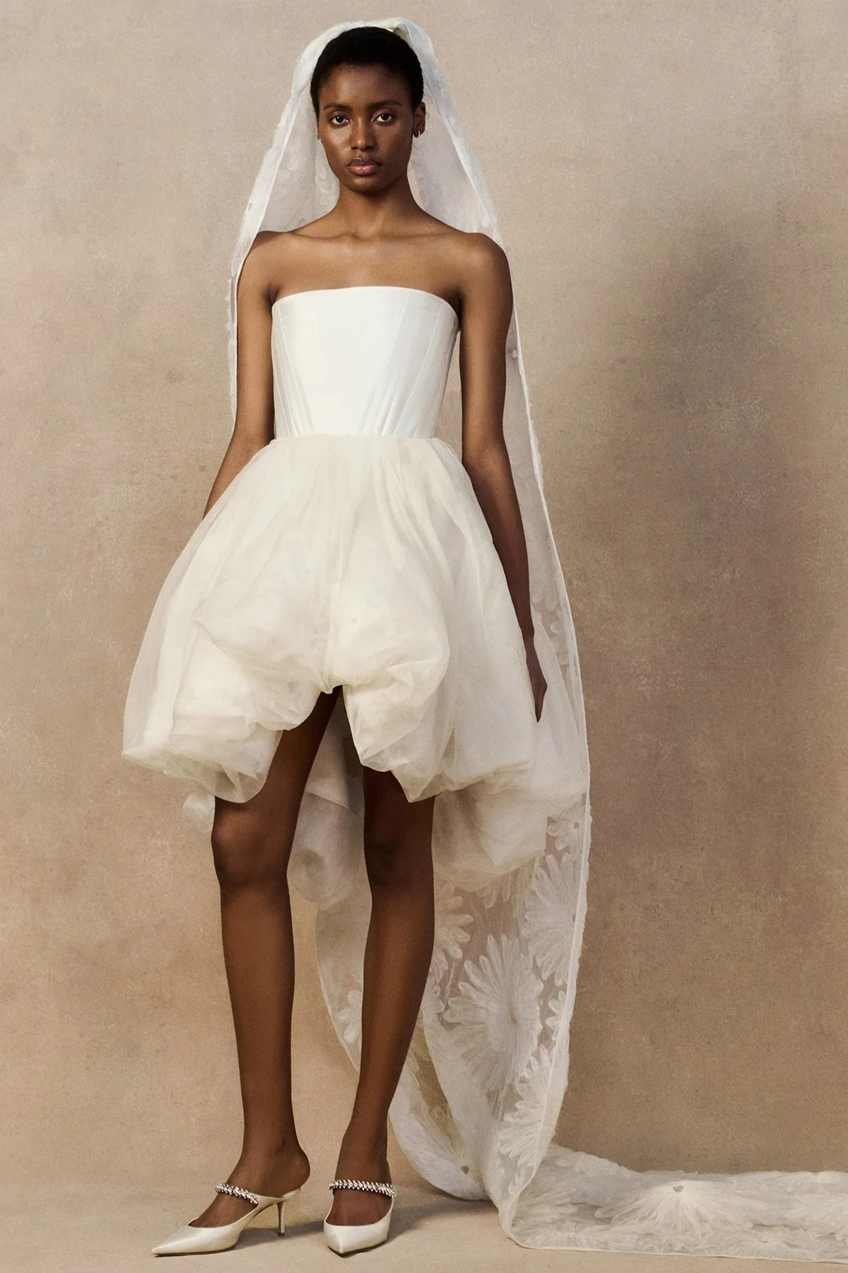 front image of Meg Mini skirt featuring looped daisy motifs in a bubble-shaped silhouette with a high-low hem. worn with fig veil and phoenix corset