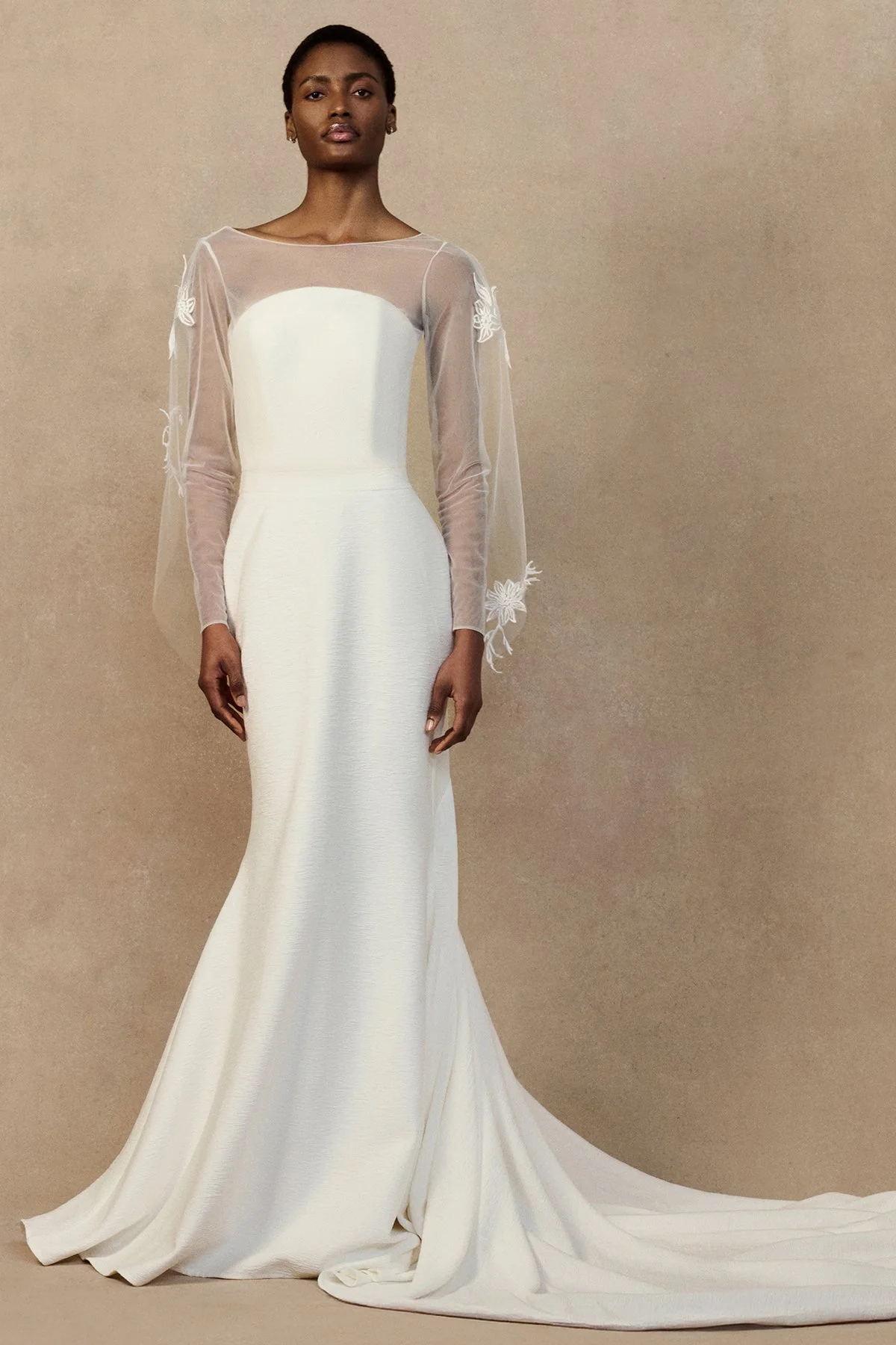 front image of sheer tulle Geum Jacket featuring a draped cowl back and a multifunctional hood that can be styled as a bridal veil. worn with strapless Nicole wedding gown