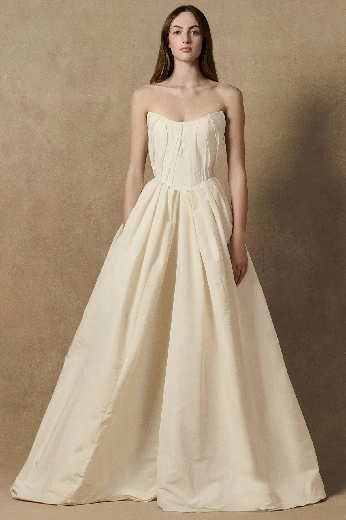 front image of Lubi dress in pleated weightless taffeta, featuring a structured support corset, shown without sleeves and full length gown