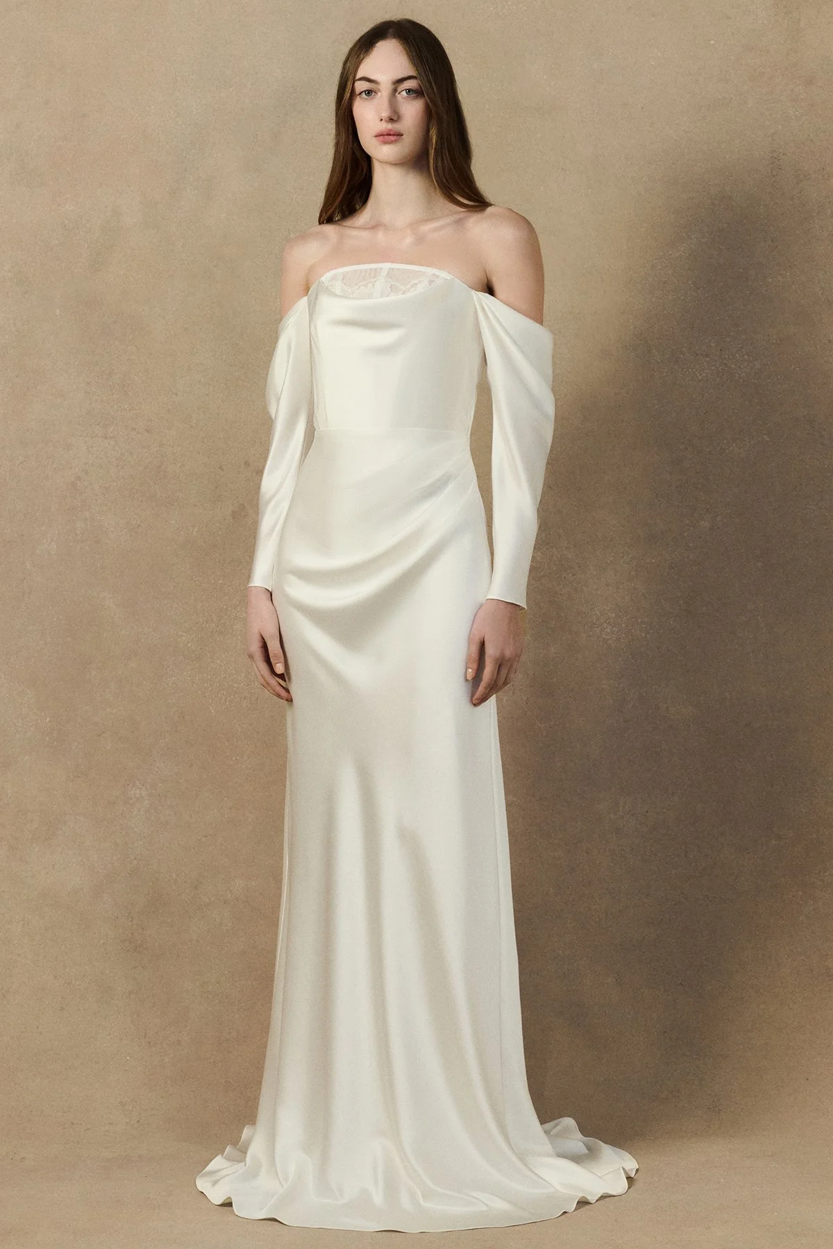 front image of Herah Dress in liquid crepe back satin featuring a cowl neckline, lace trim details, and an draped skirt. worn with sleeves