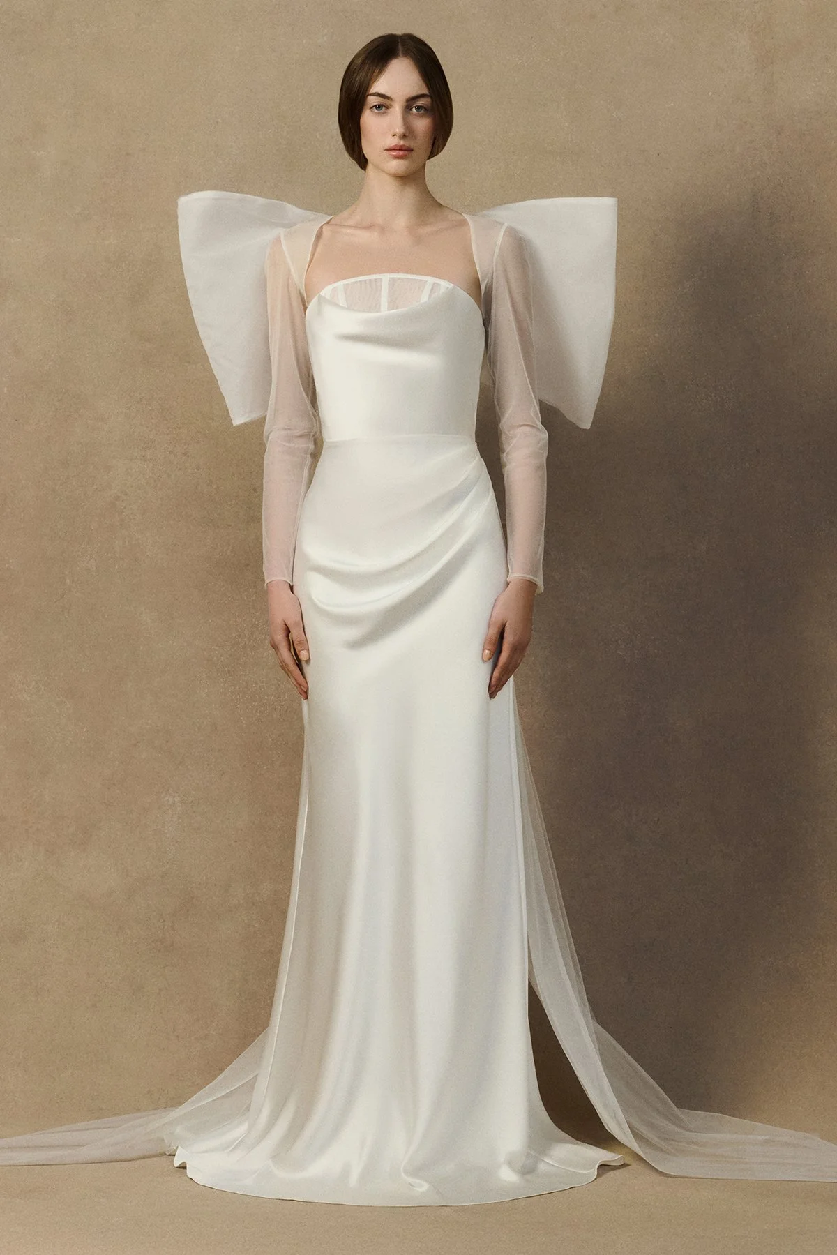 front image of oversized bridal bow jacket crafted from layered tulle, organza, and crinoline, styled as a sheer bolero. worn with herah dress