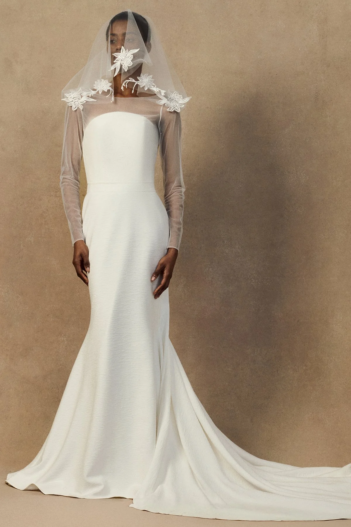 front image of sheer tulle Geum Jacket featuring a draped cowl back and a multifunctional hood that can be styled as a bridal veil. worn with strapless Nicole wedding gown