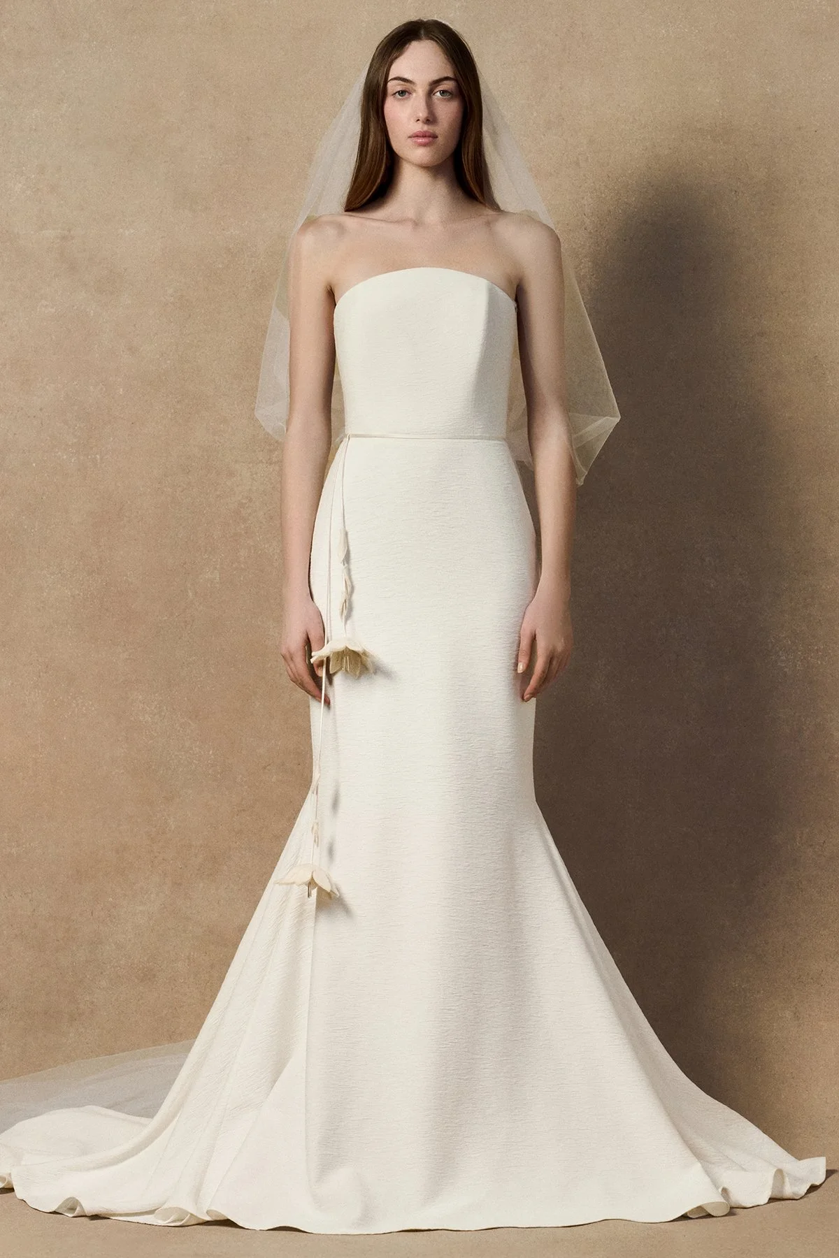 front image of white wedding gown nicole dress in plissé-textured cloqué featuring a curved upward neckline without sleeves. With Phyllis veil