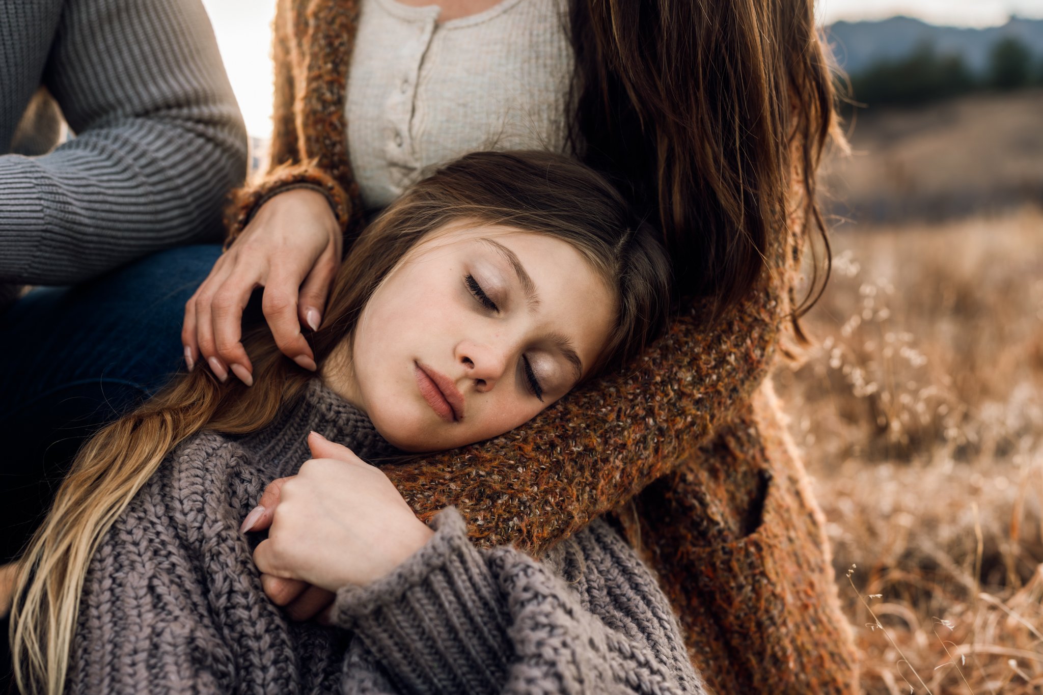 Daugther leans against her mom with her eyes closed while mom strokes her hair | Boulder Photographer