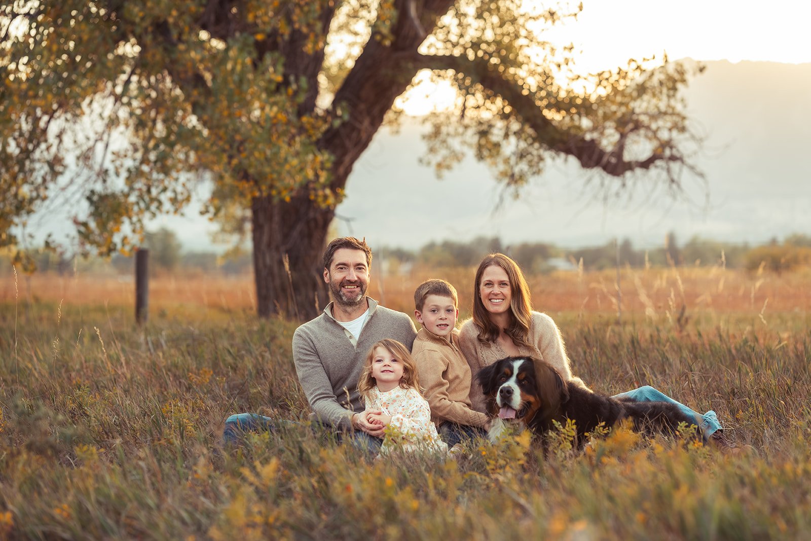 Family sits together in the golden light at Bobolink trailhead in Boulder
