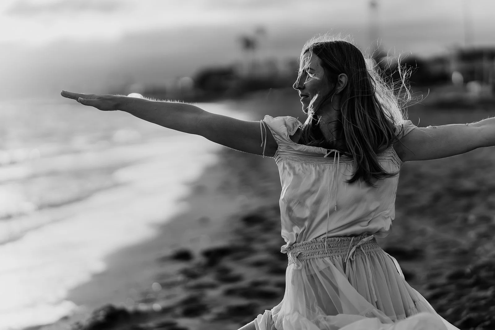 a branding client doing yoga| In black and white, a woman does a yoga pose along the beach