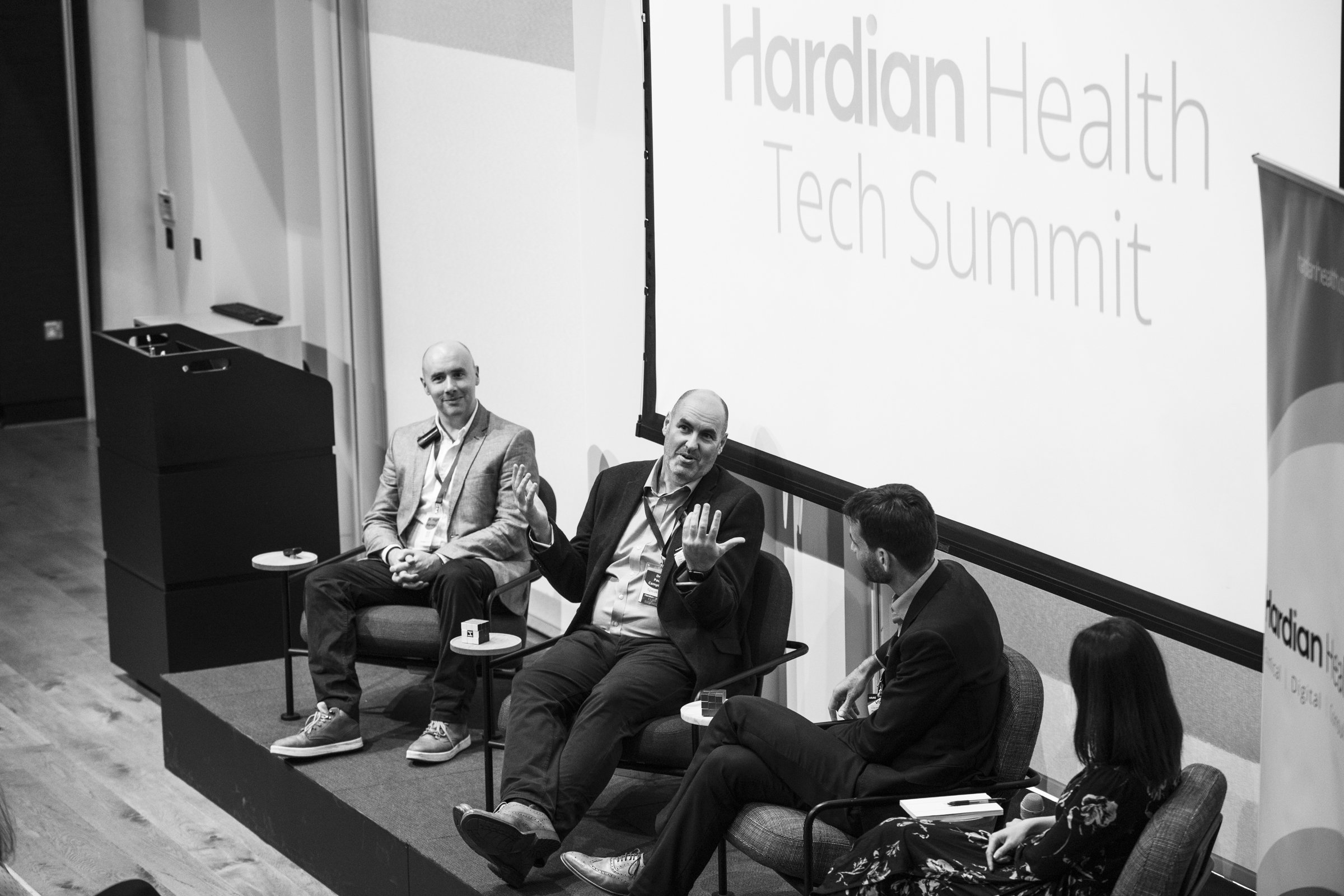Panel discussion at Hardian Health Tech Summit with four participants seated on stage, engaging in conversation.