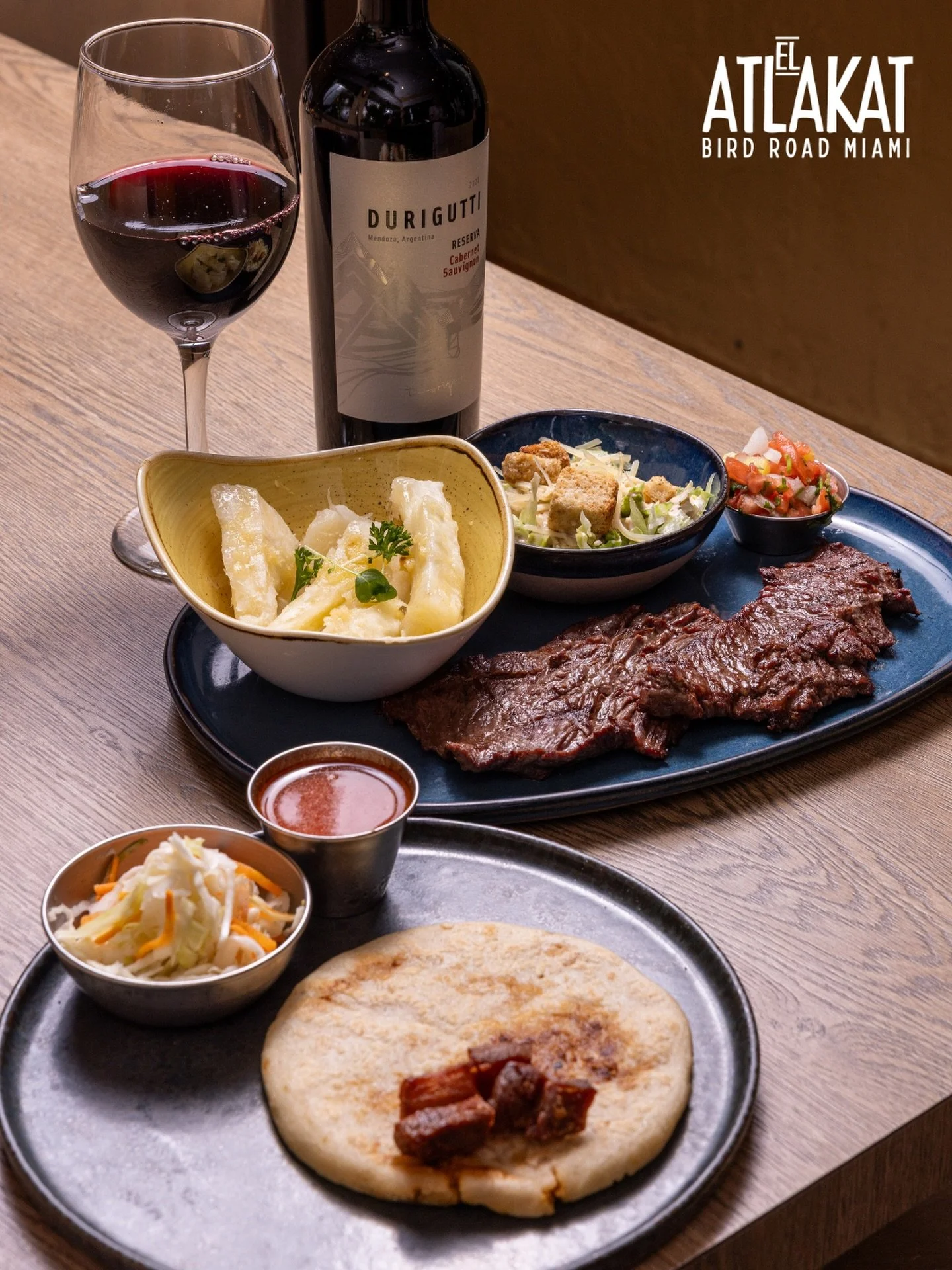 Carne asada, pupusa, yuca and a glass of red wine. This is what a proper dinner looks like. ✨

ONLY AT BIRD ROAD: 9425 S.W. 40th. Street. Miami, FL 33165&nbsp;
💻 Orders, delivery and reservations at www.elatlakat.com
☎️ (305-552-9090) or ☎️ (305-552