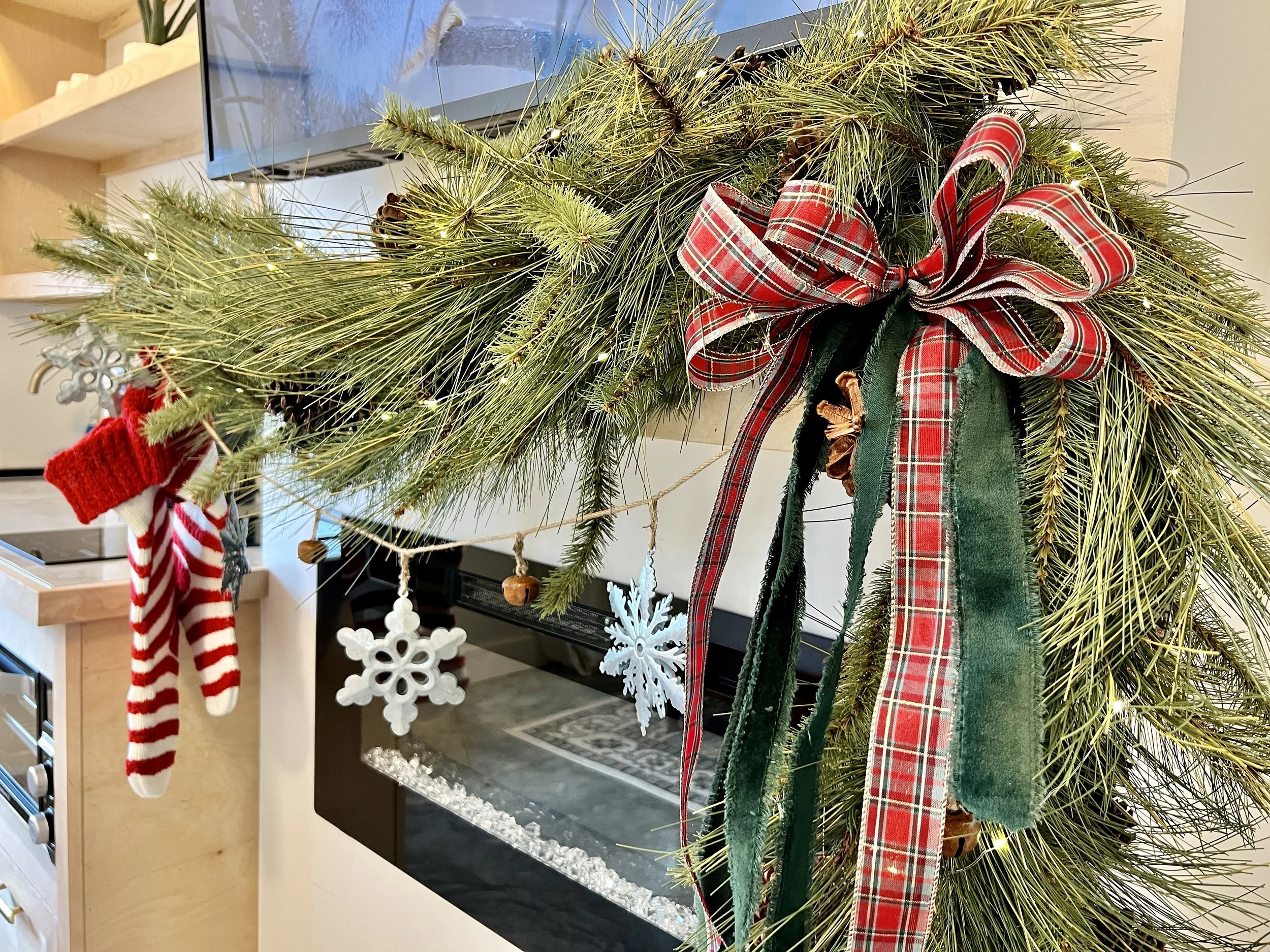 Christmas garland with pine branches, plaid ribbon, and hanging stockings.