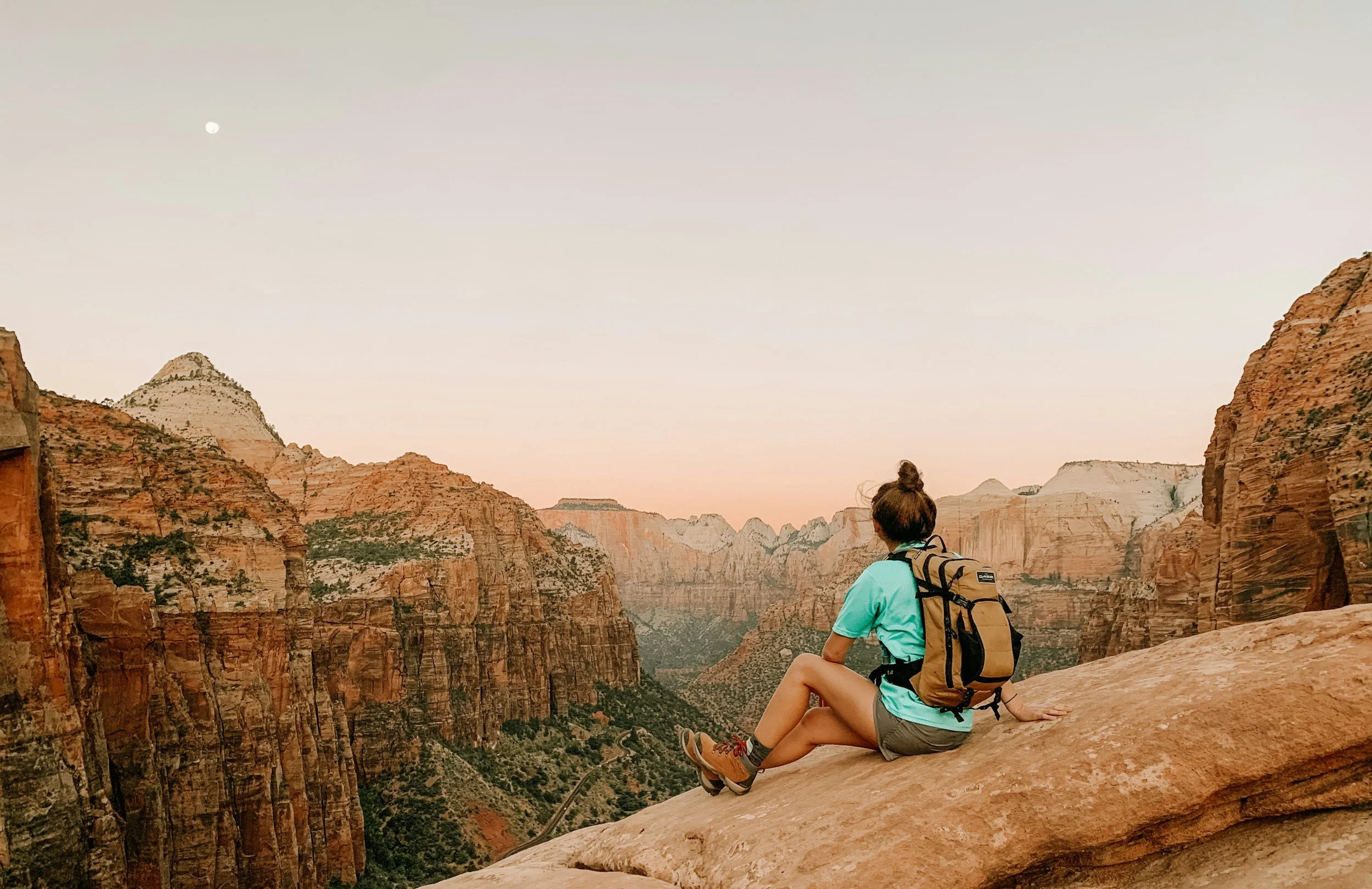 Woman sitting on a boulder at high elevation.