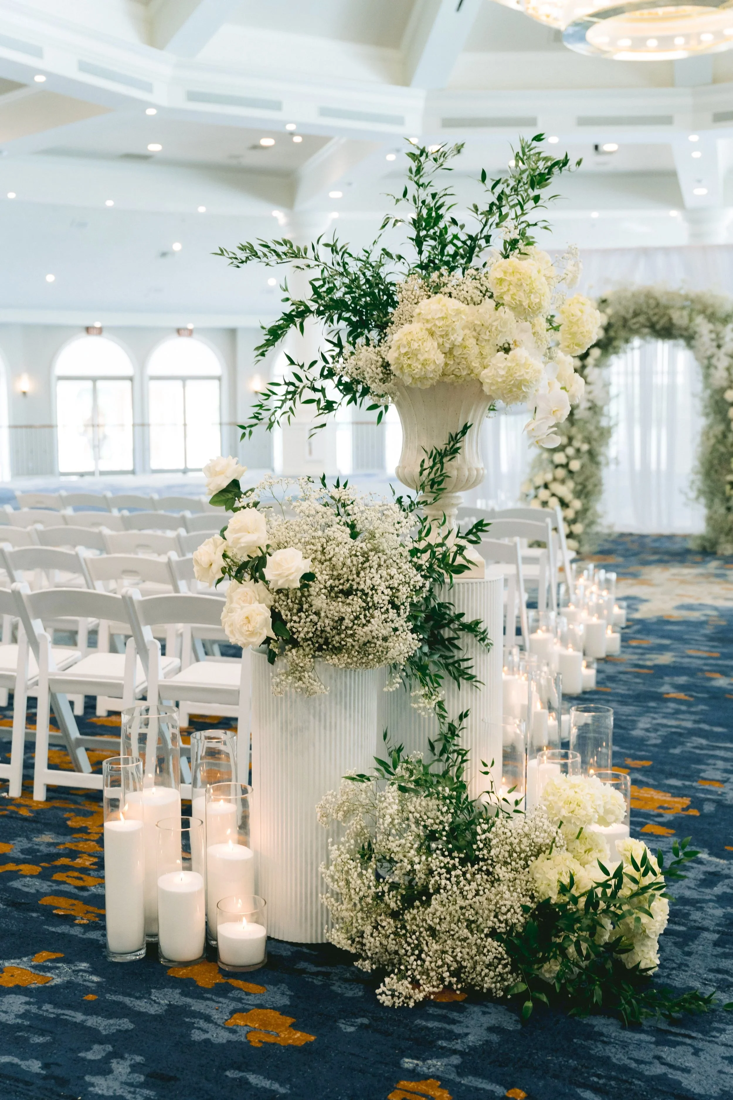 White hydrangea and olive branch urn arrangement lining a candlelit ceremony aisle, Las Vegas wedding florals by Thistle House