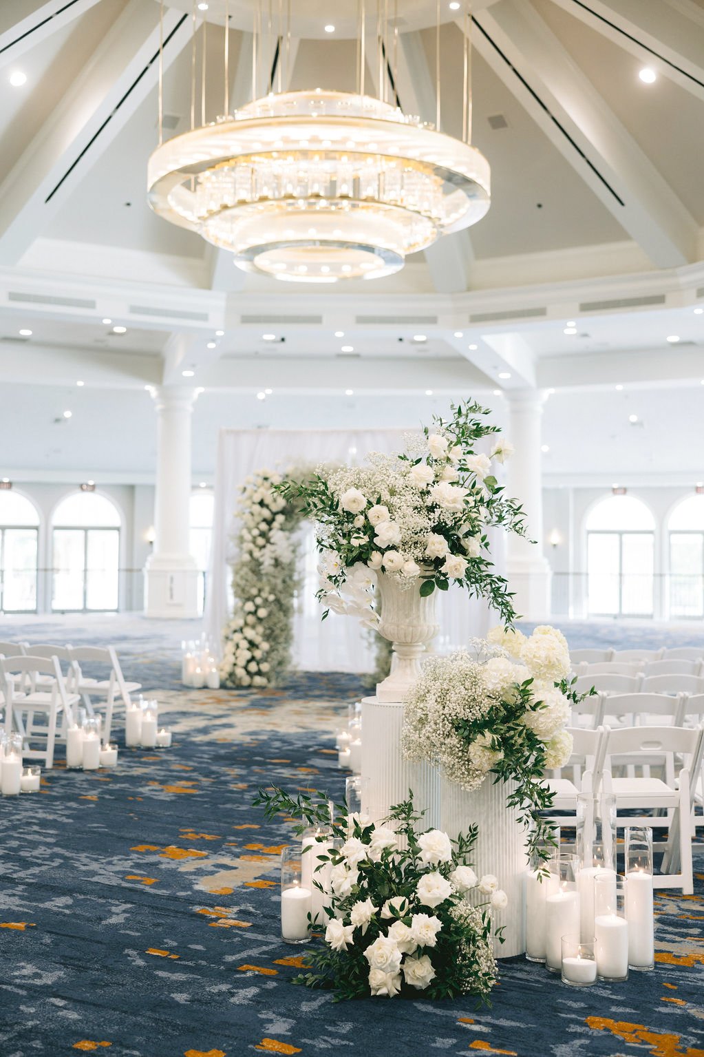 Tall white hydrangea and baby's breath pedestal arrangement in a chandelier ballroom, Las Vegas wedding florist ceremony décor