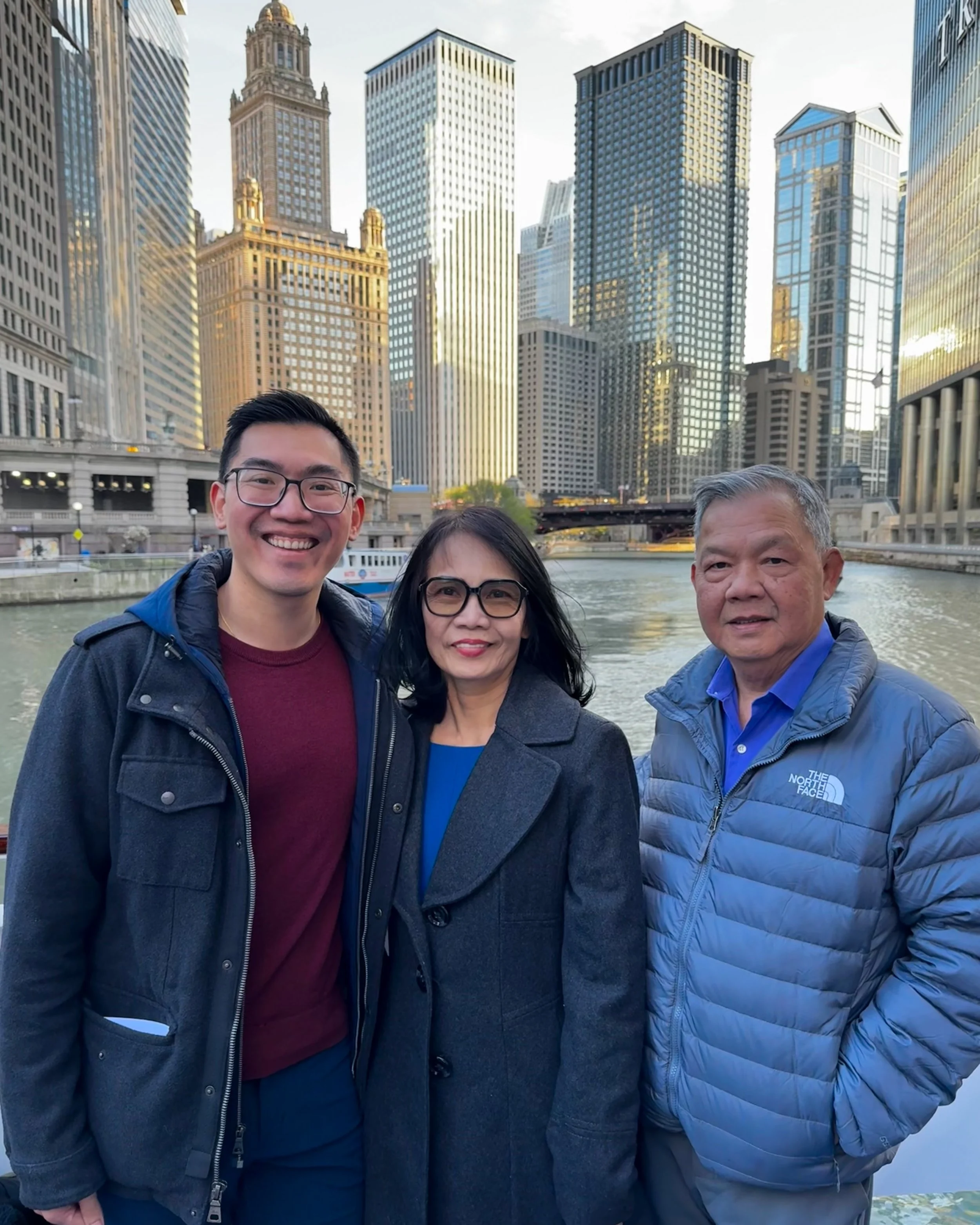 A family on a Pack Up + Go trip to Chicago posing in front of the river