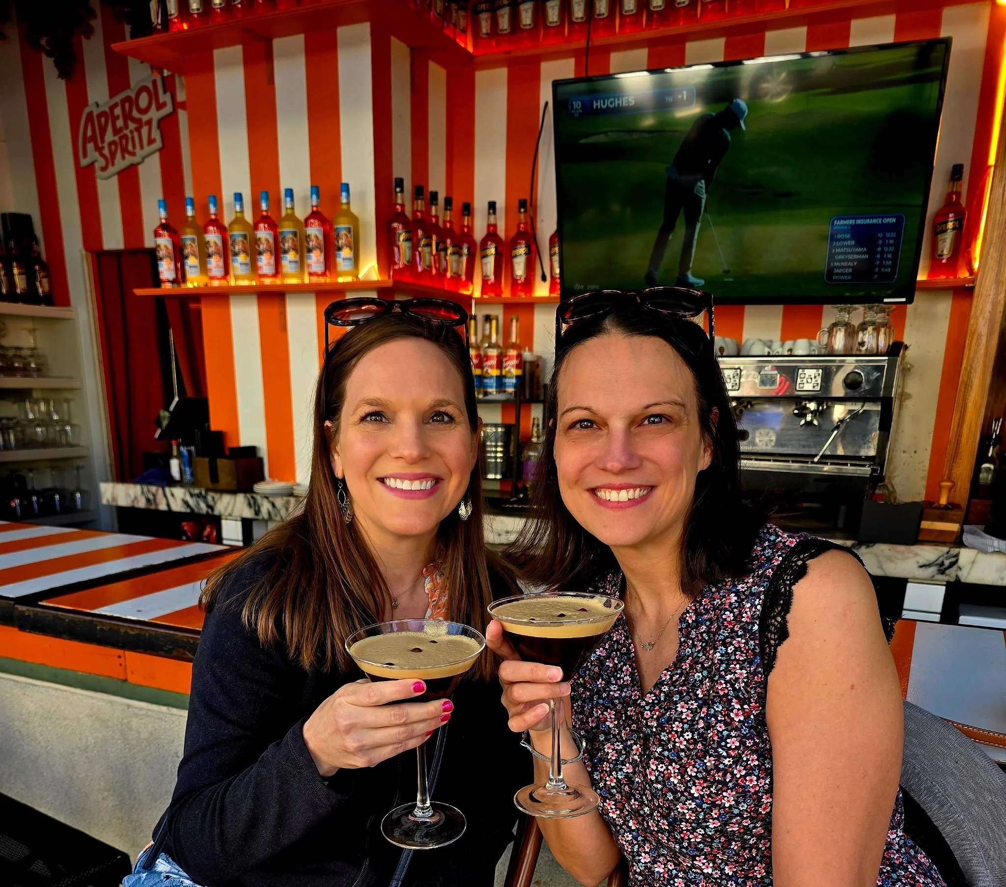 Two girl friends on their Pack Up + Go trip enjoying a cocktail on a rooftop bar for their kids-free weekend