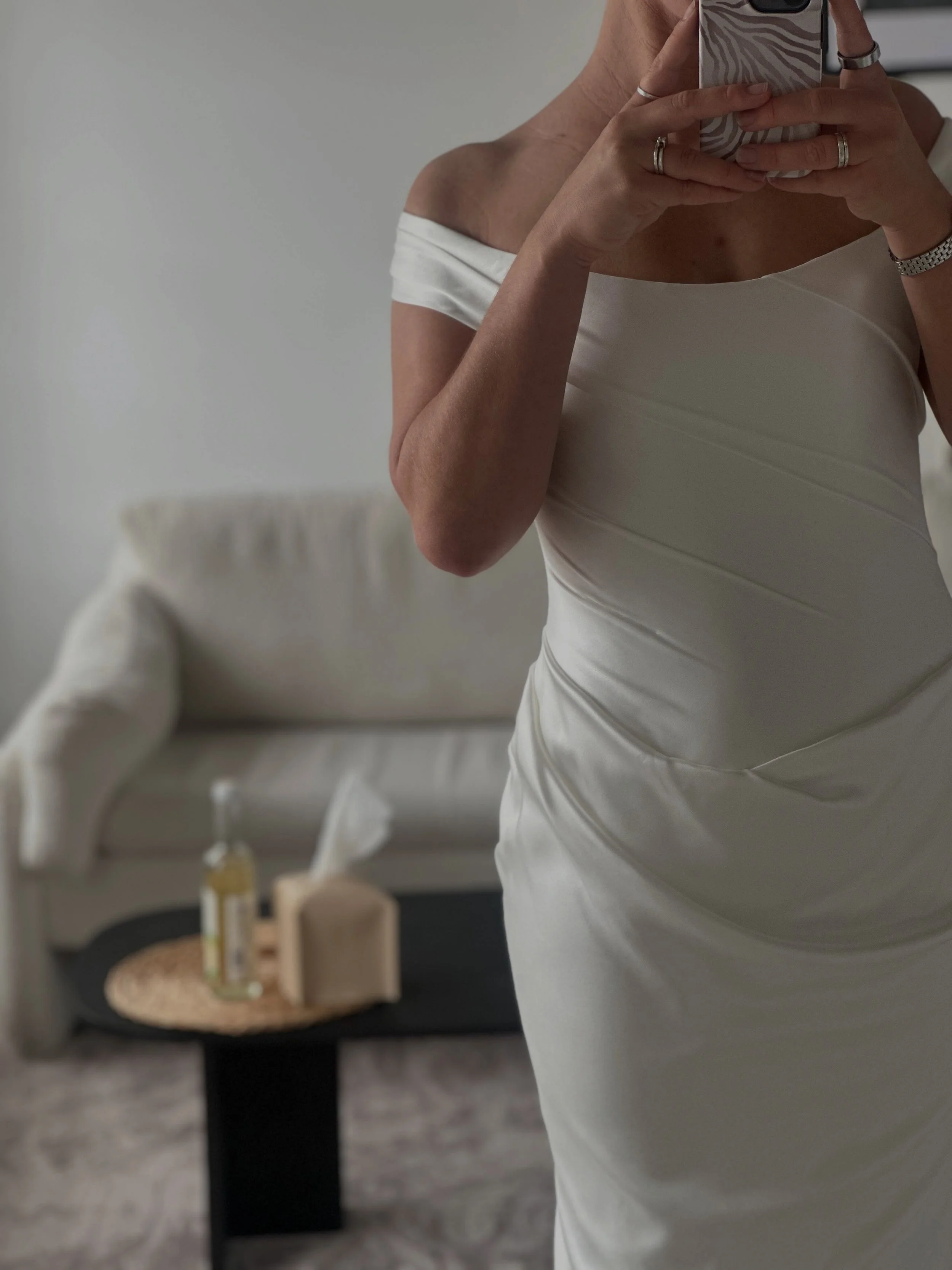 NIA by KYHA 

Off Shoulder draped front gown with fit and flare skirt with train.

Irreverent glamour takes the spotlight in Nia. Cut from sleek double satin, Nia features a highly structured bodice with a tight drape and a fit-and-flare skirt cut to