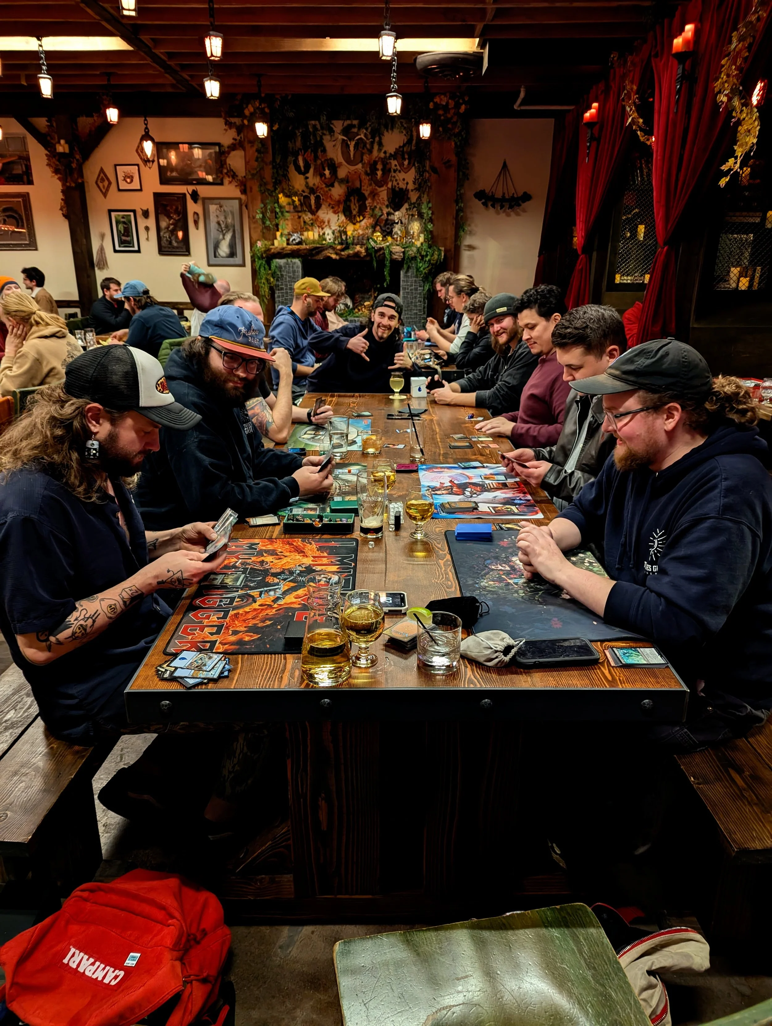 A picture of thieves guilds long table with Magic players focused on their games.