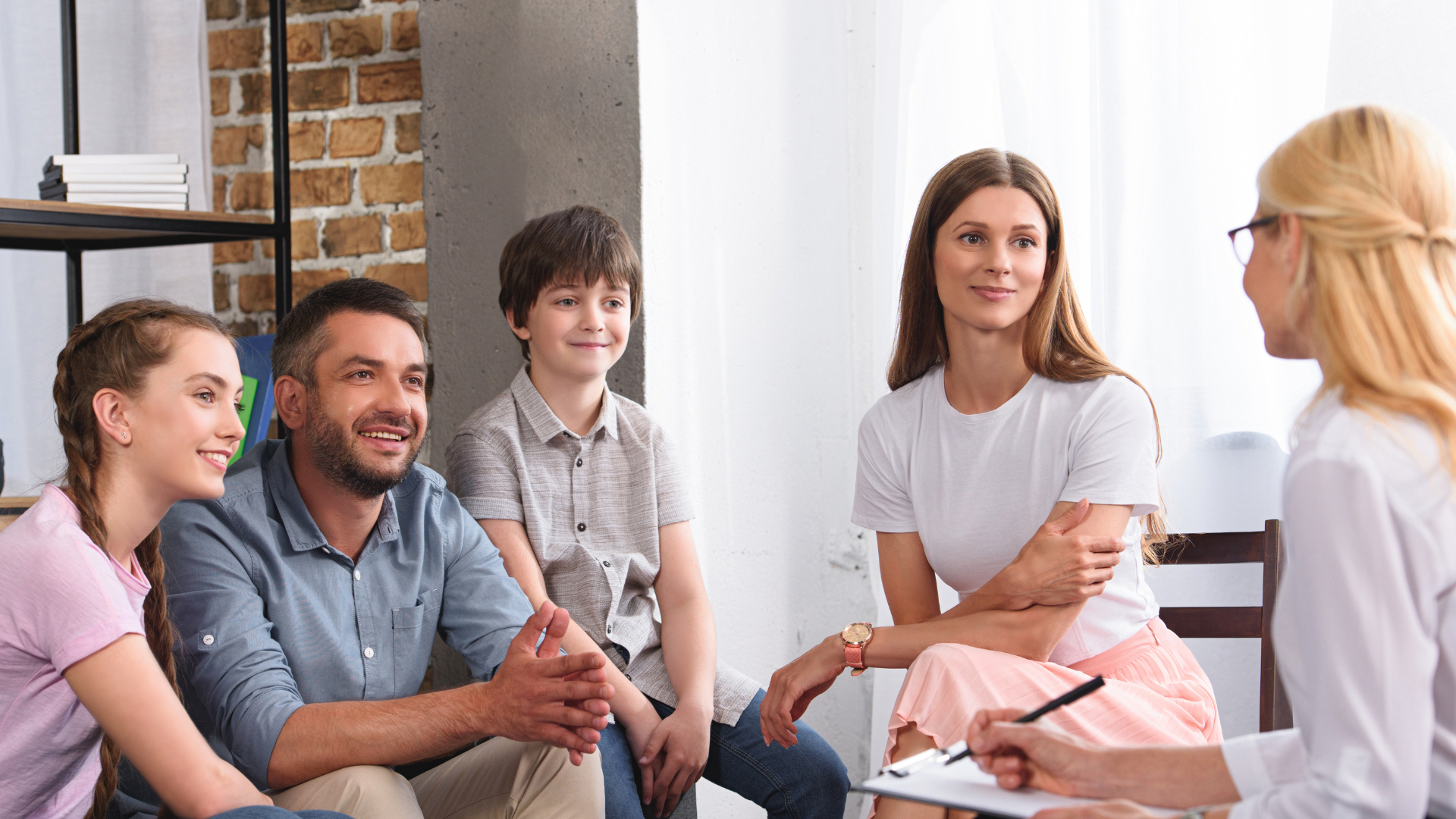 A family consulting a therapist in a bright, modern therapy office.