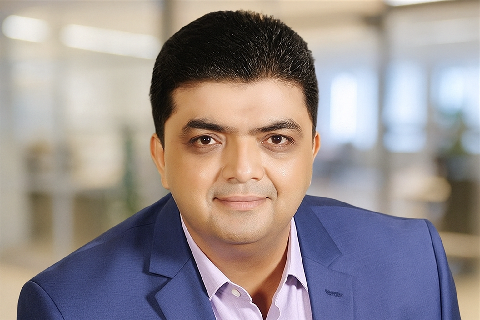 Man smiling at a conference with booths in the background.