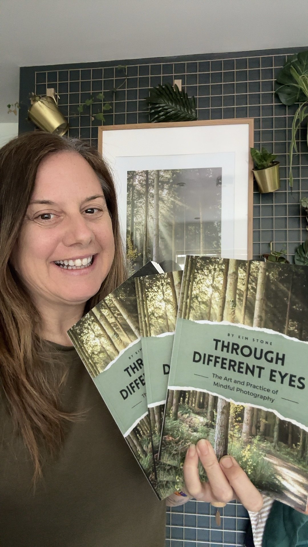 Kim Stone holding copies of her book "Through Different Eyes - The Art and Practice of Mindful Photography"