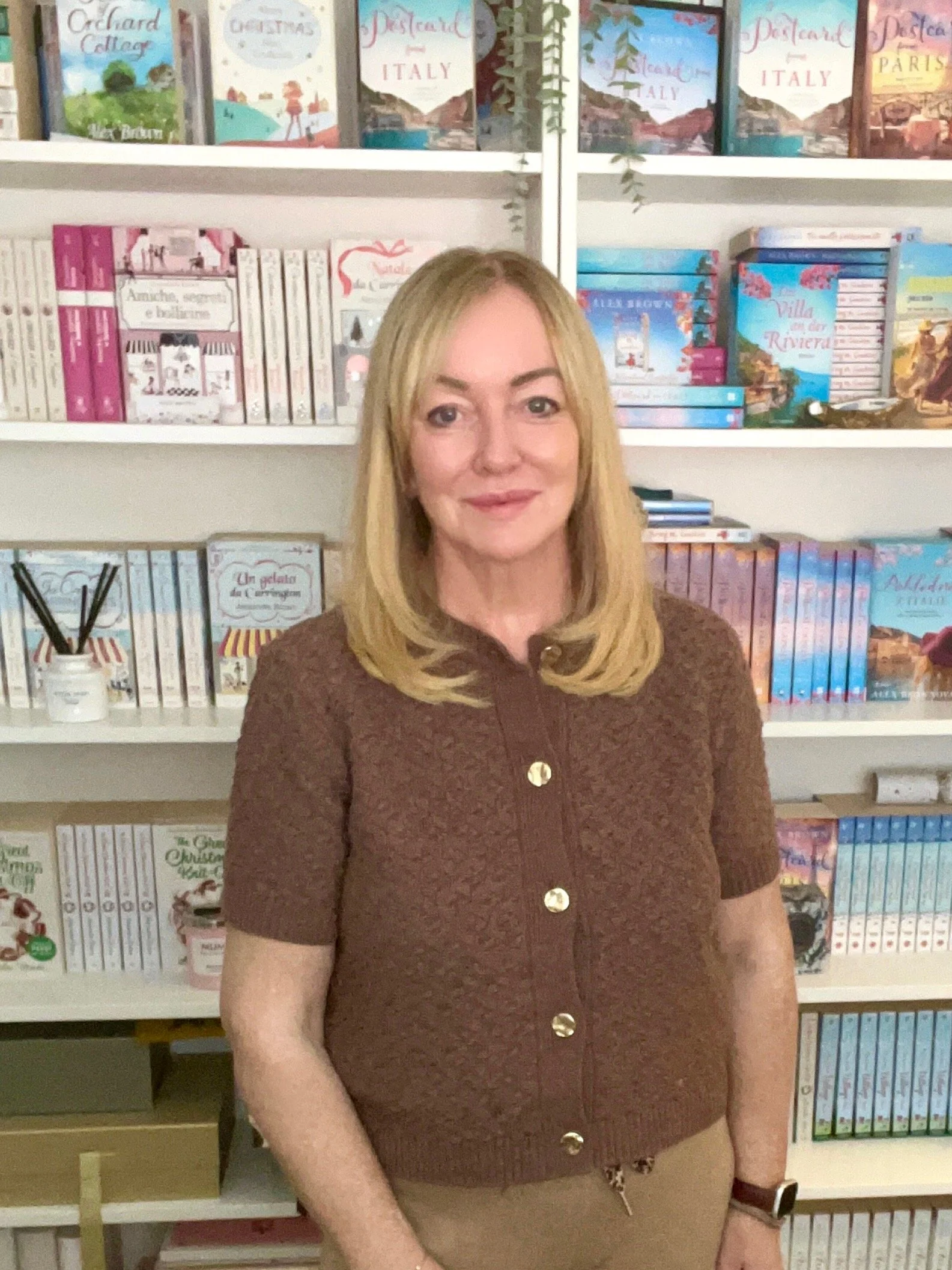 Alex brown author standing in front of a selection of her books