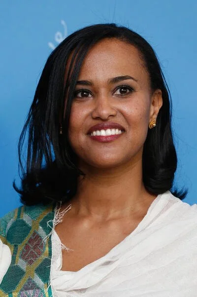 image of Dr Mehret Mandefro looking directly into the camera wearing a white blouse with a patterned scarf