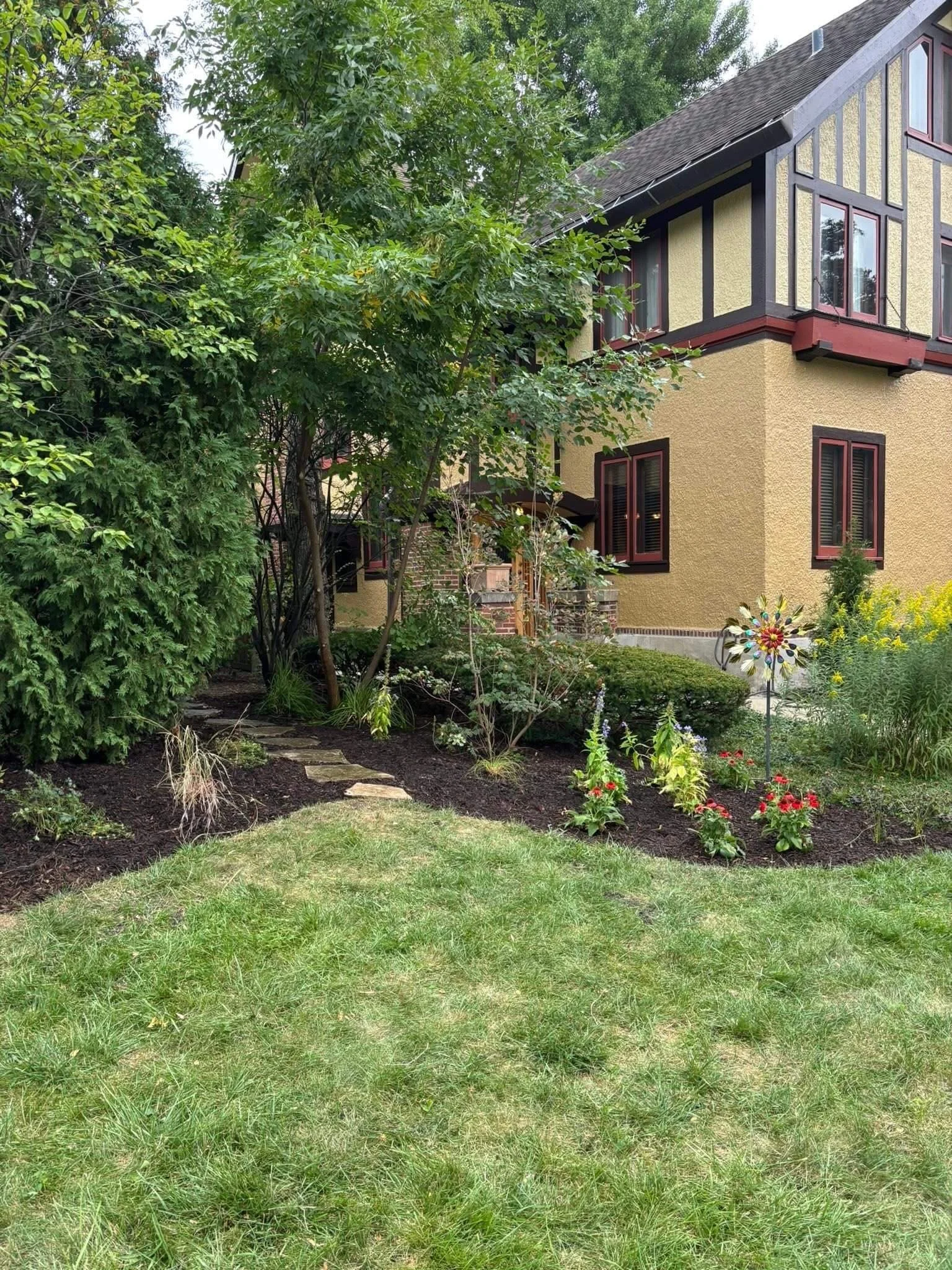 Finished Chicago front yard with native garden design framing a historic home with layered plantings and defined beds