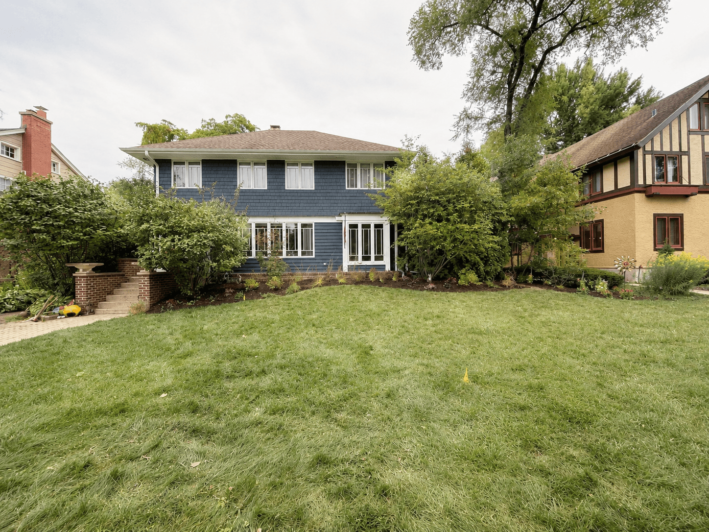 After: a cleaner, more open front yard with defined bed lines, fresh plantings, and room for the house to breathe again.